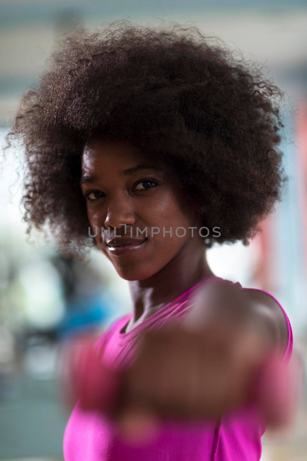 happy healthy african american woman working out in a crossfit gym on weight loss with dumbbells