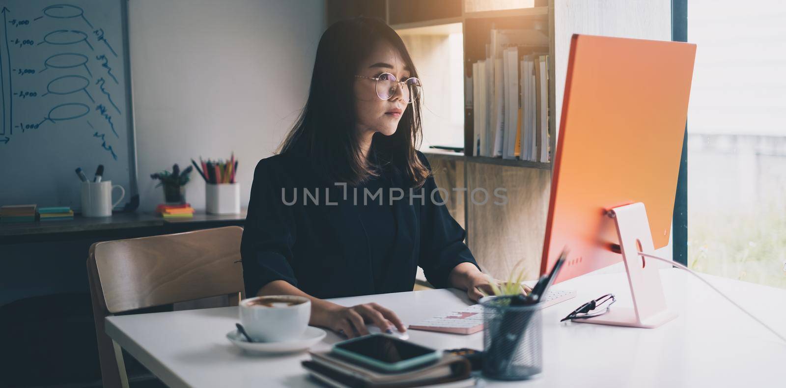 Cheerful young asian woman working with computer at home. Student female in living room. online learning, studying , online shopping, freelance, asean concept by itchaznong