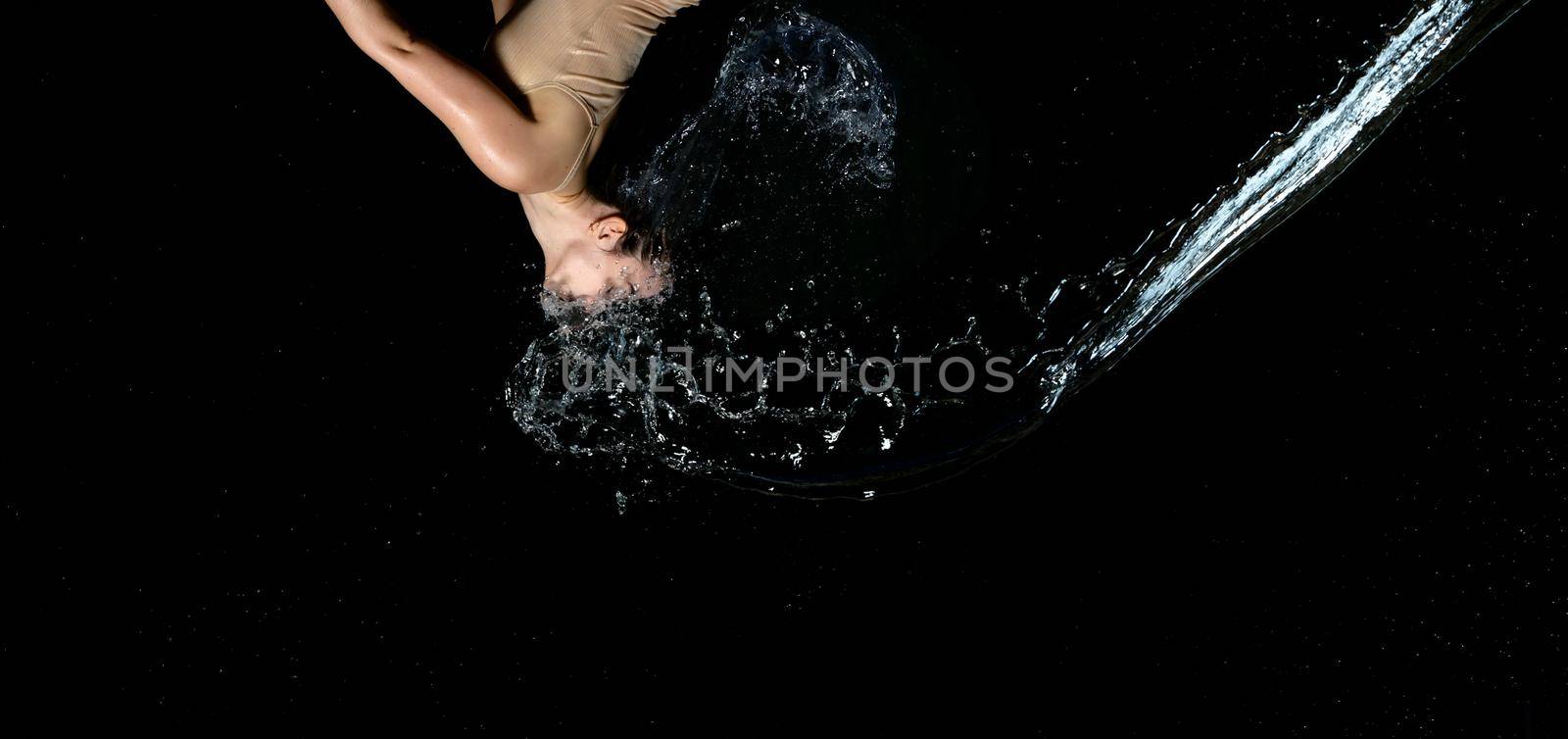 beautiful woman of Caucasian appearance with black hair in drops of water on a black background by ndanko