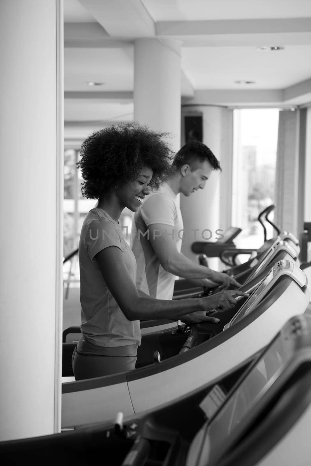 young people exercisinng a cardio on treadmill running chine in modern gym