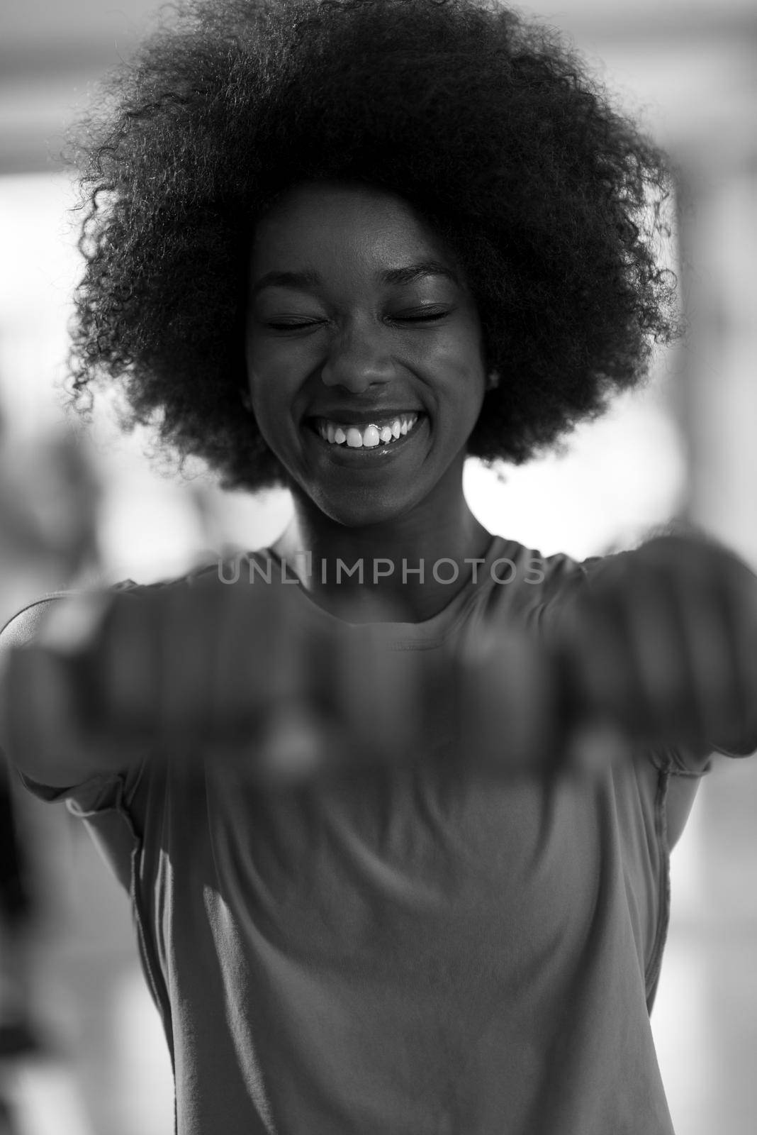 happy healthy african american woman working out in a crossfit gym on weight loss with dumbbells