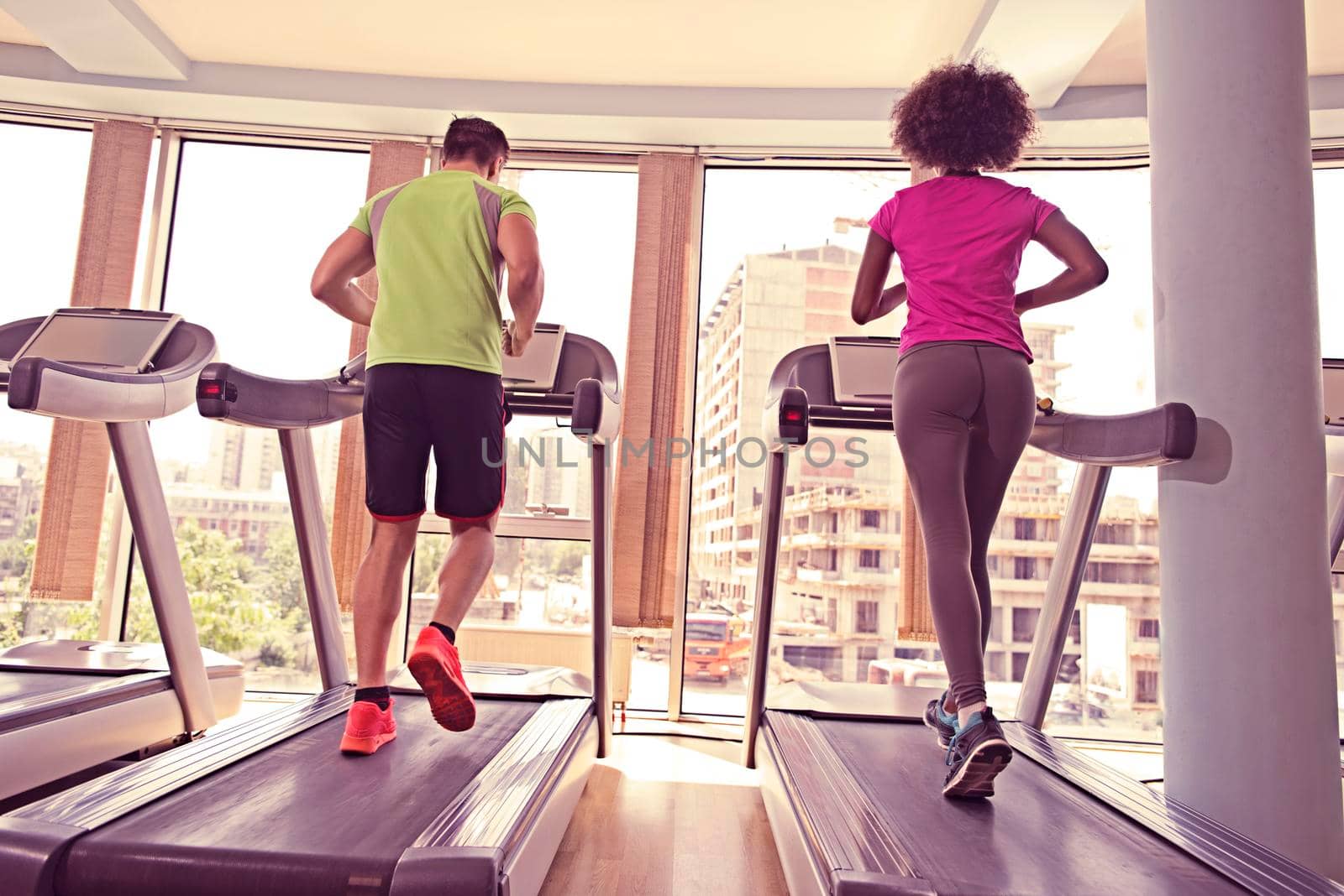 young people exercisinng a cardio on treadmill running machine in modern gym