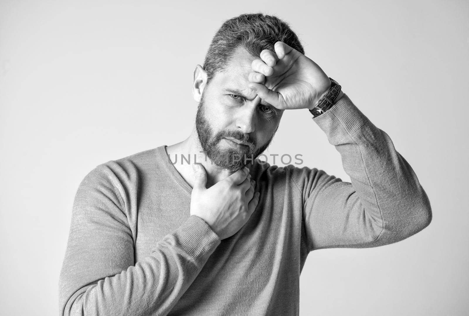 mature man with beard has heacache suffer from headahce on grey background, malaise.