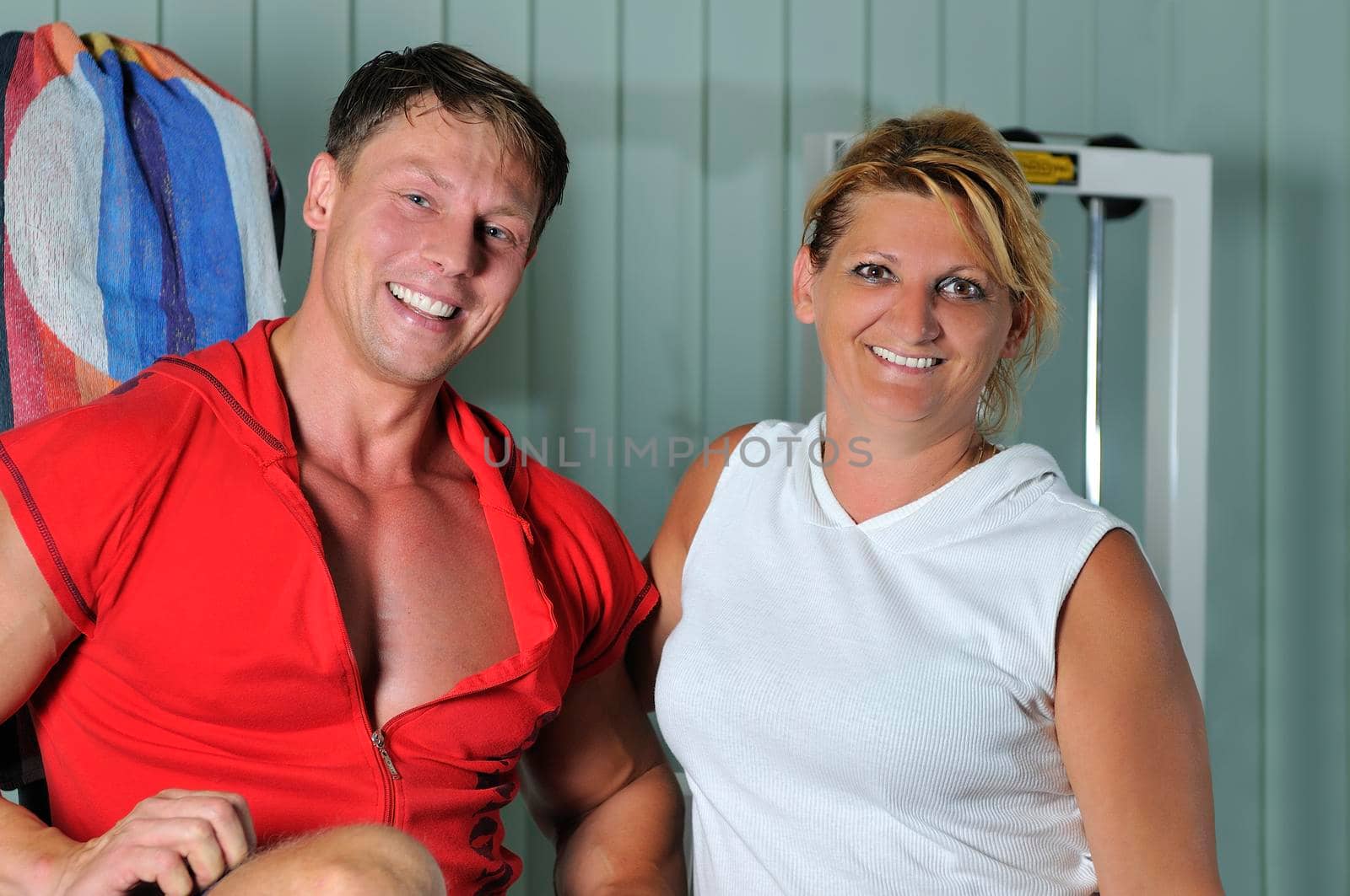 Mature woman smiling with fitness trainer by dotshock