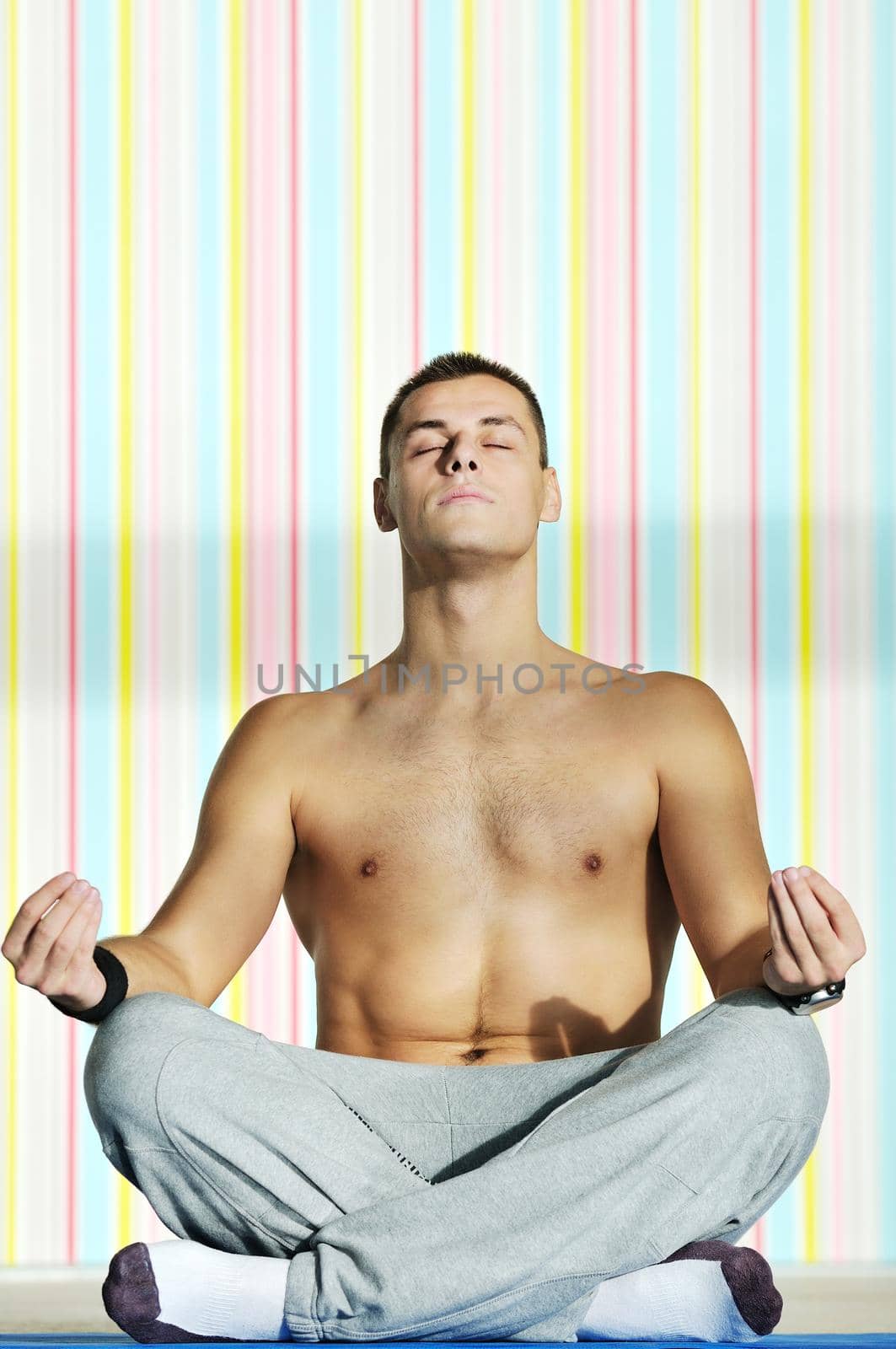 young man exercise and practice yoga fitness  in lotus position indoor in fitness club