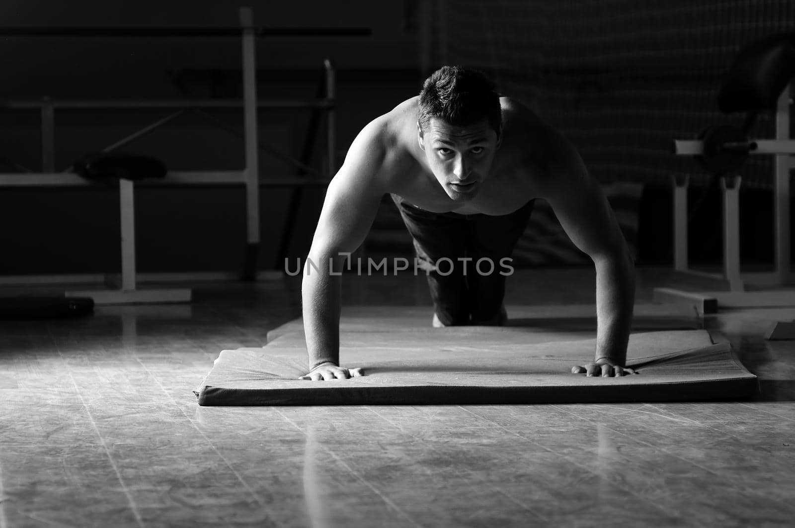 young man with strong arms working out in gym and representing their streinght and vitality