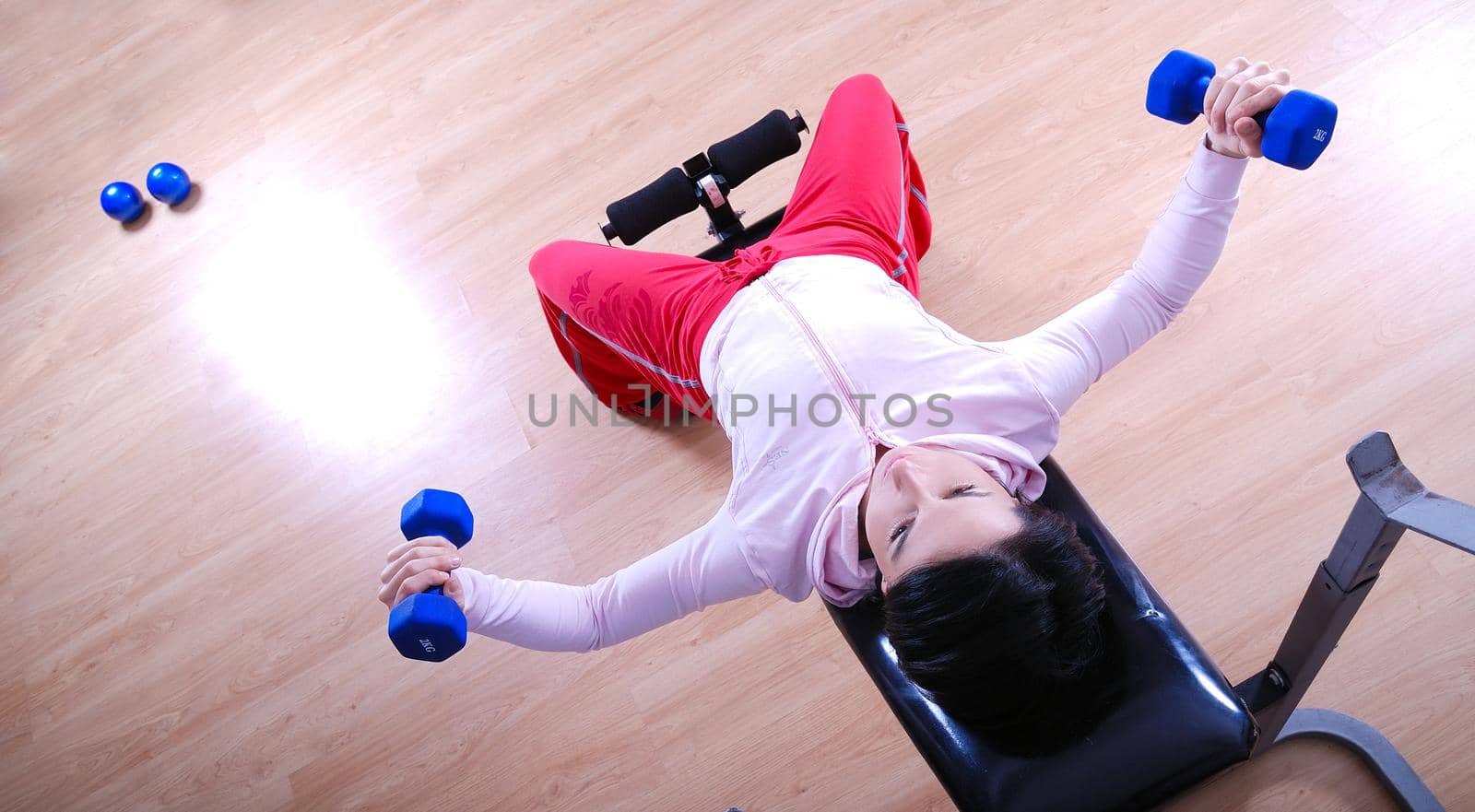 .a young woman weightlifting at gym  by dotshock