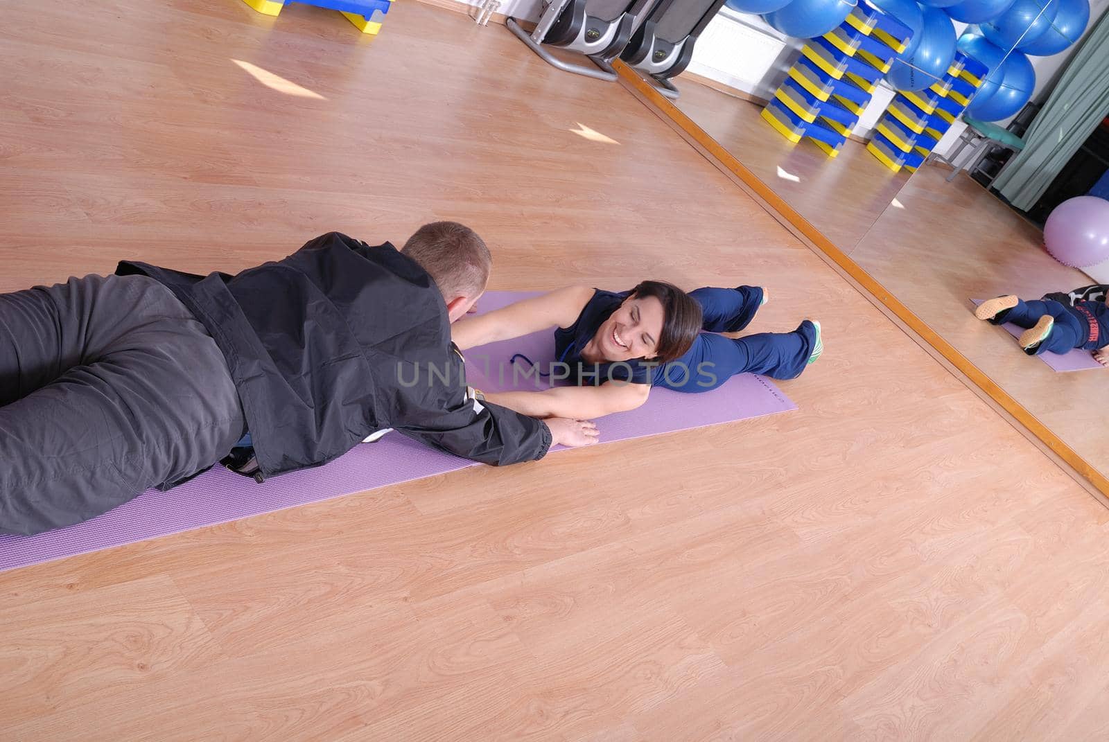 .happy couple at gym working out by dotshock