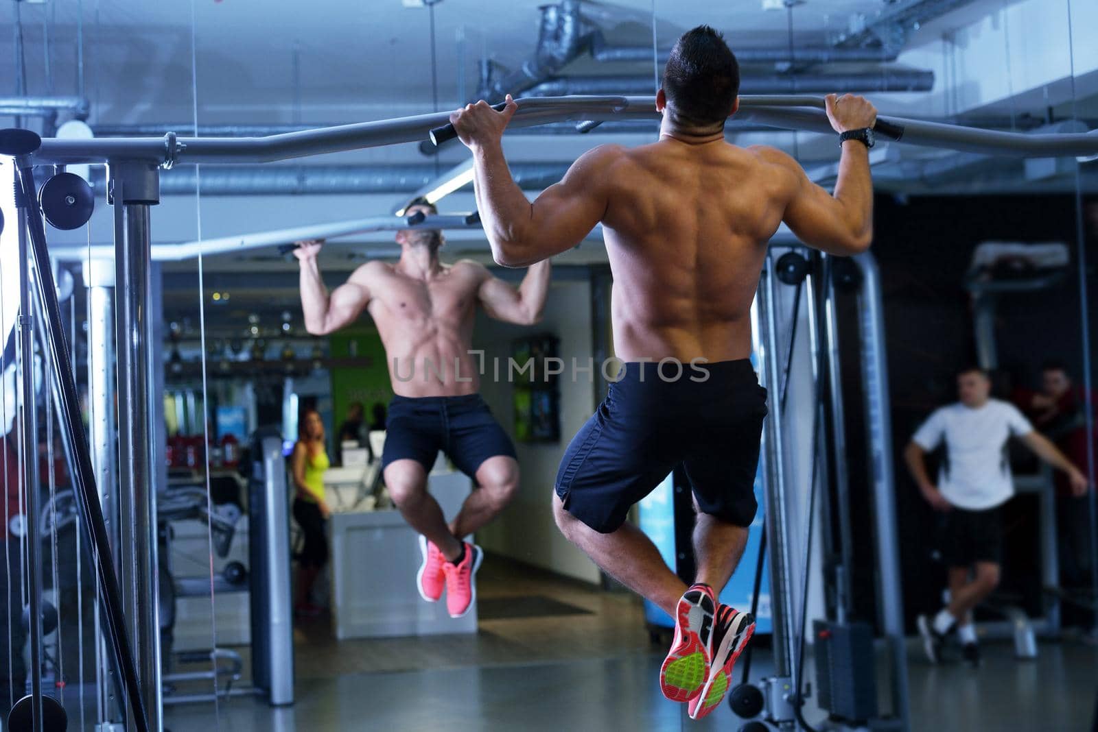 Strong handsome man exercising at the gym