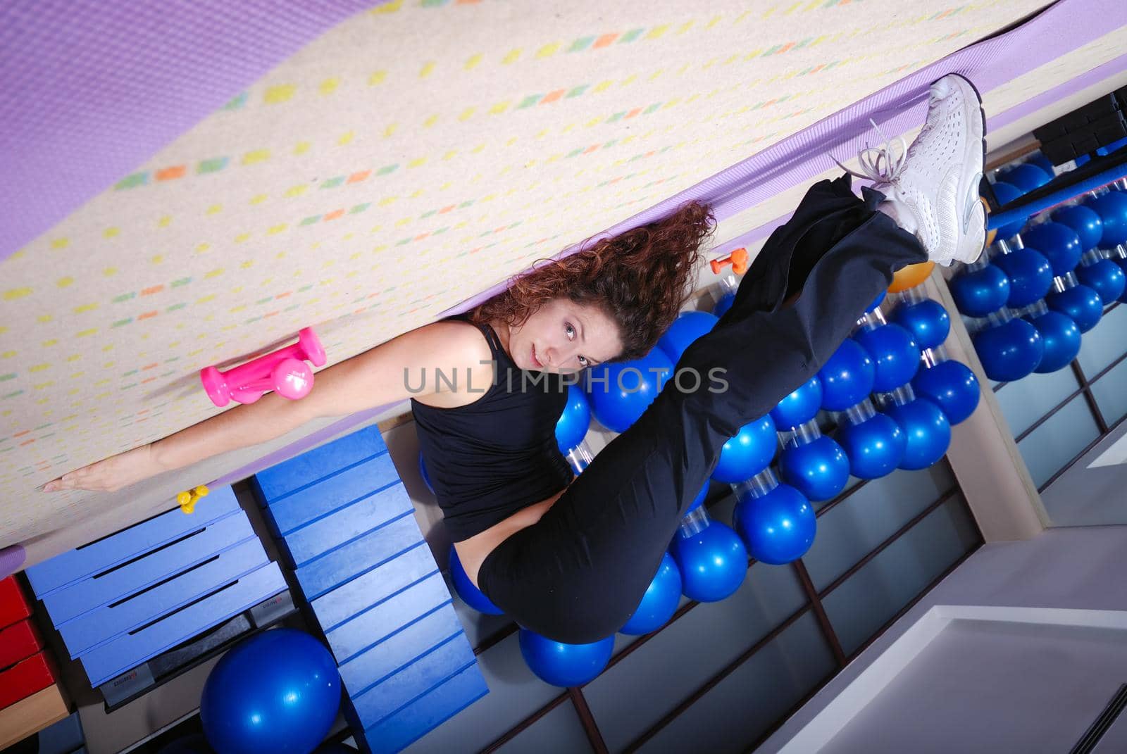 pretty girl warming up andd streching in fitness studio