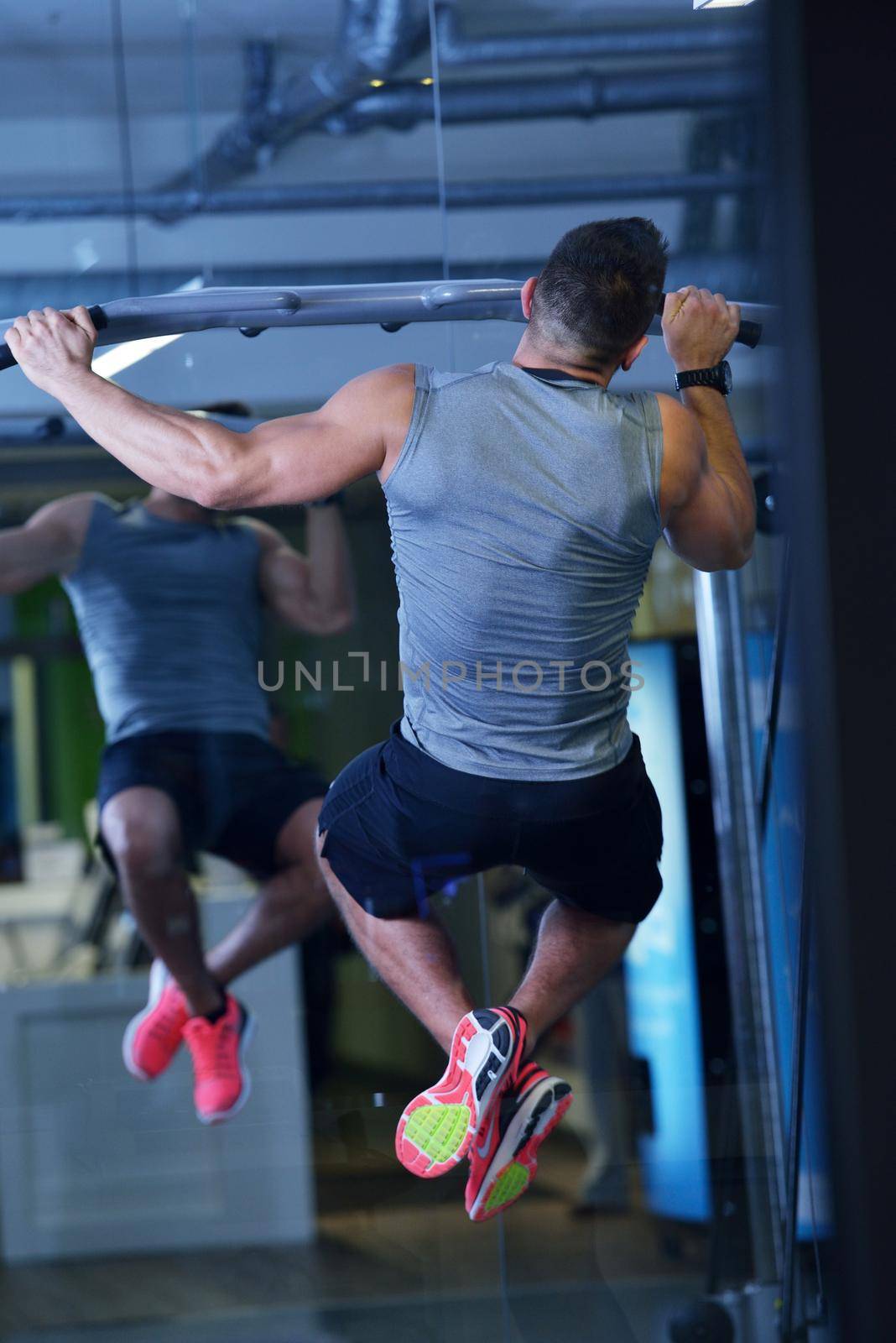 Strong handsome man exercising at the gym