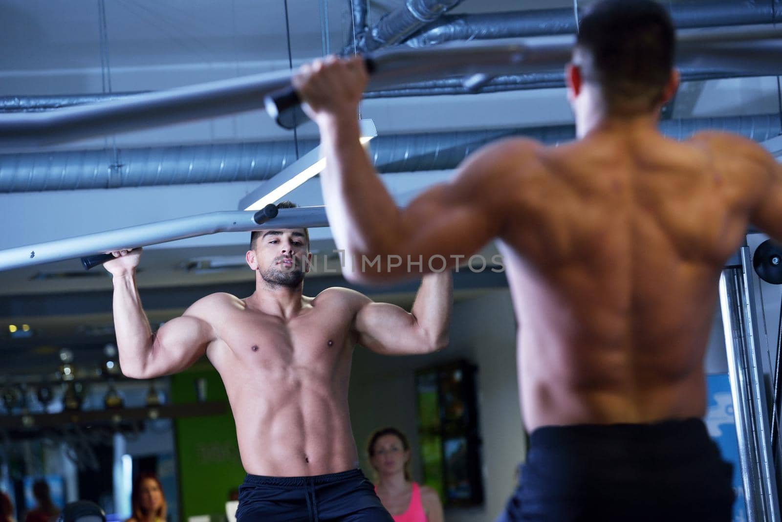 Strong handsome man exercising at the gym