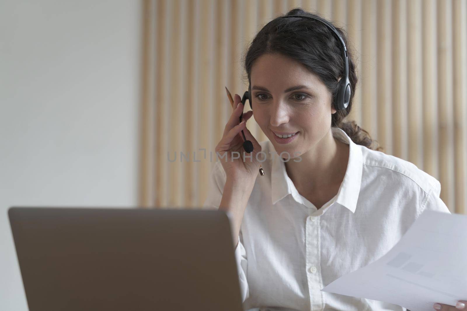 Young italian woman call center agent in headset talking with client, consulting customer online by vkstock
