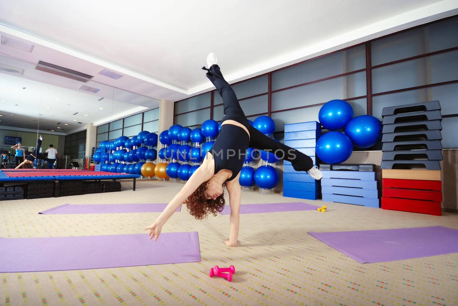 Pretty girl exercising in a fitness studio by dotshock