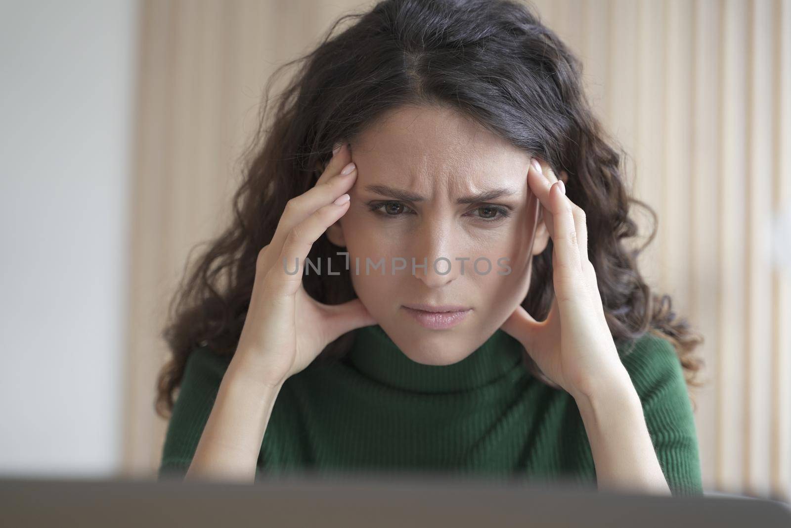 Concerned young italian woman employee looking at computer screen with frustrated face expression by vkstock