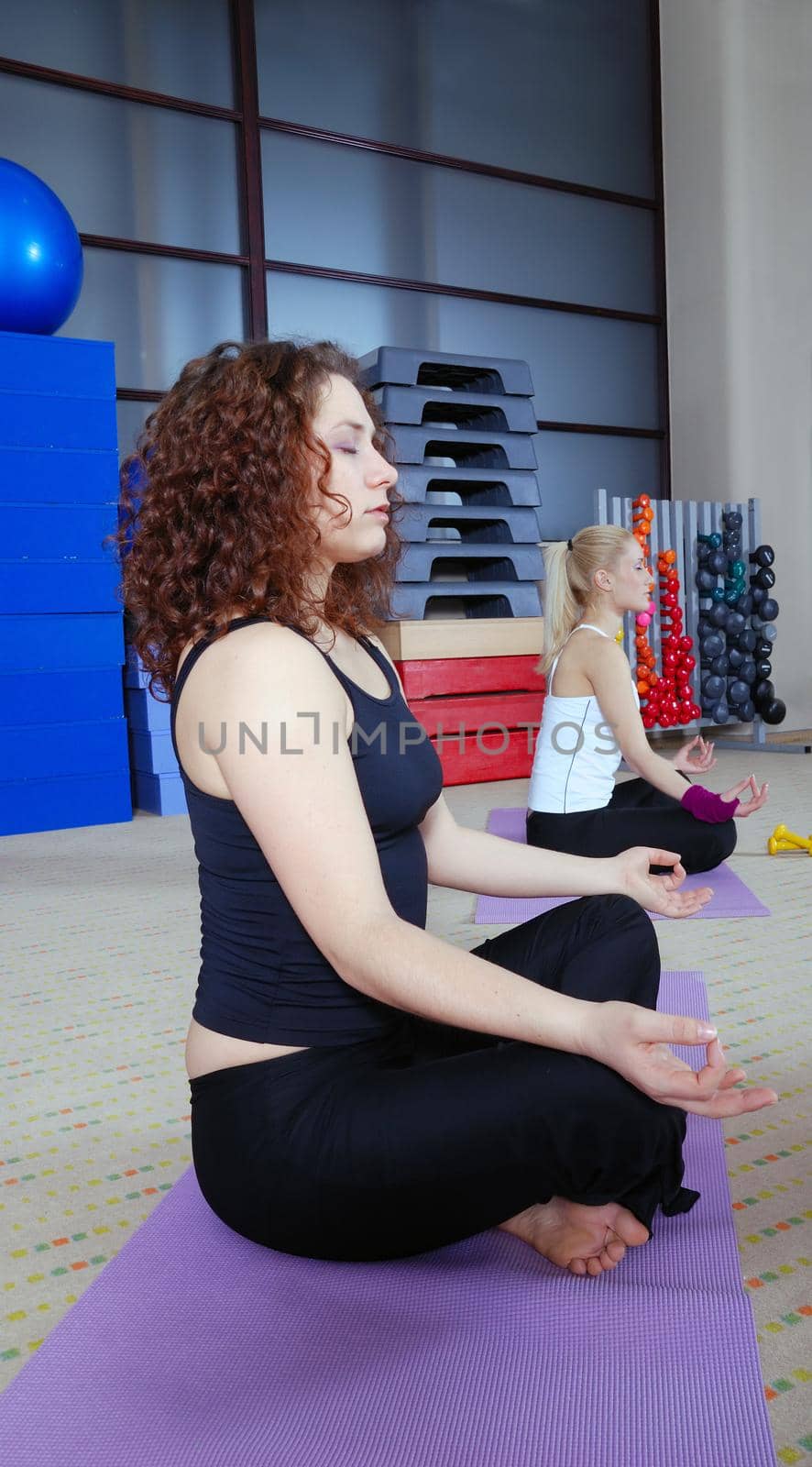 group of girl exercising yoga in fitness club