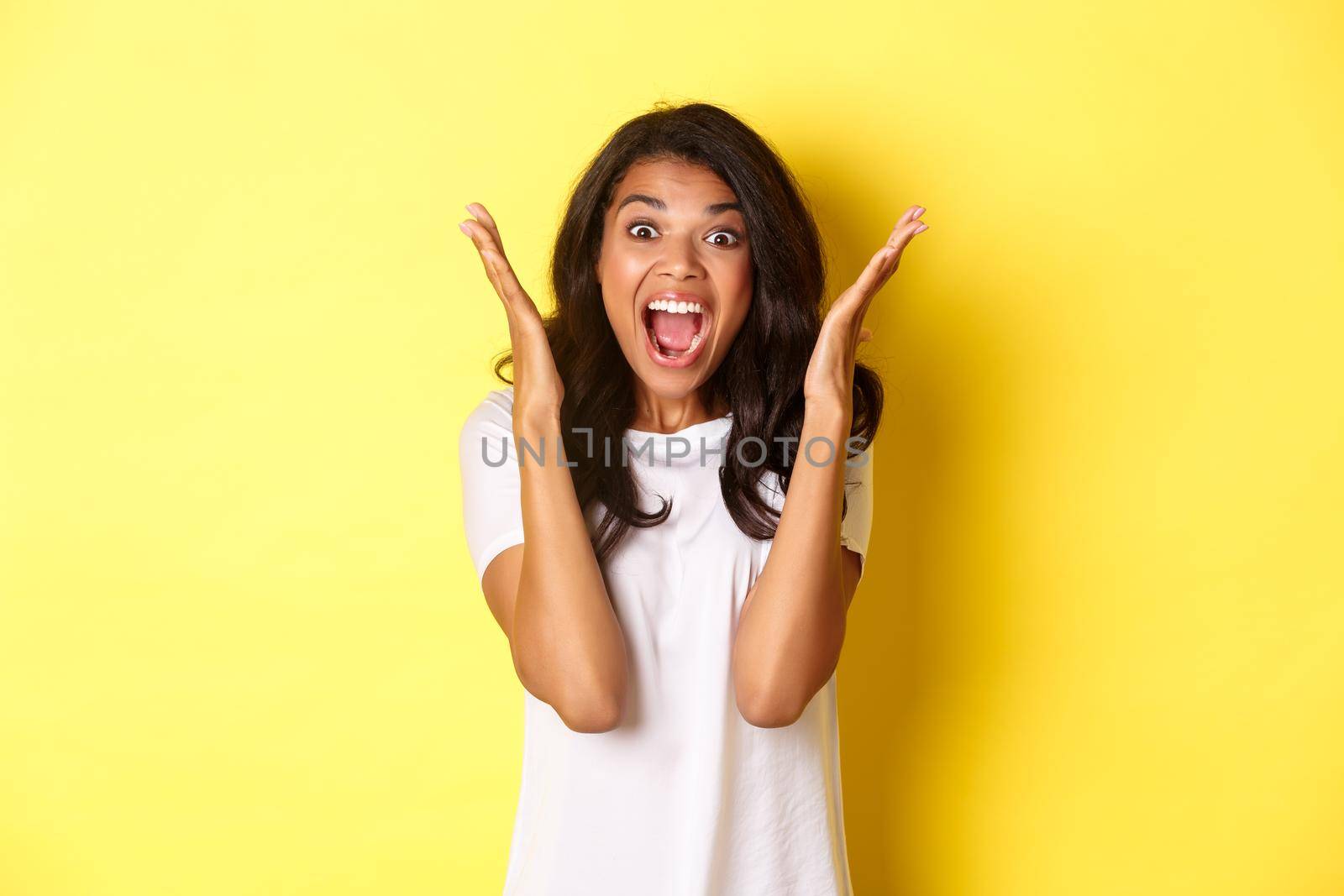 Image of young african american woman looking annoyed, screaming bothered and angry, standing over yellow background by Benzoix