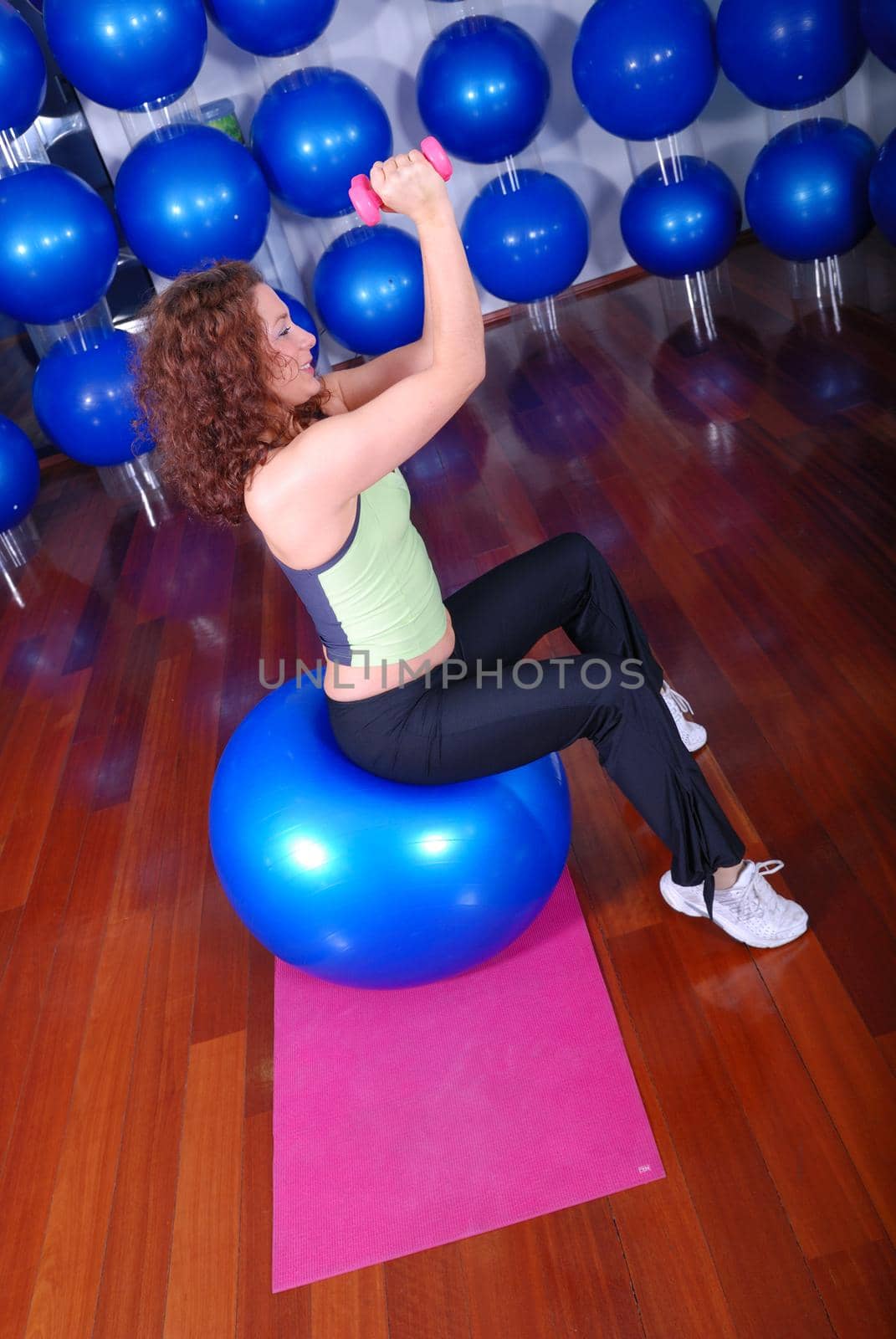 young pretty woman exercising in a fitness center by dotshock