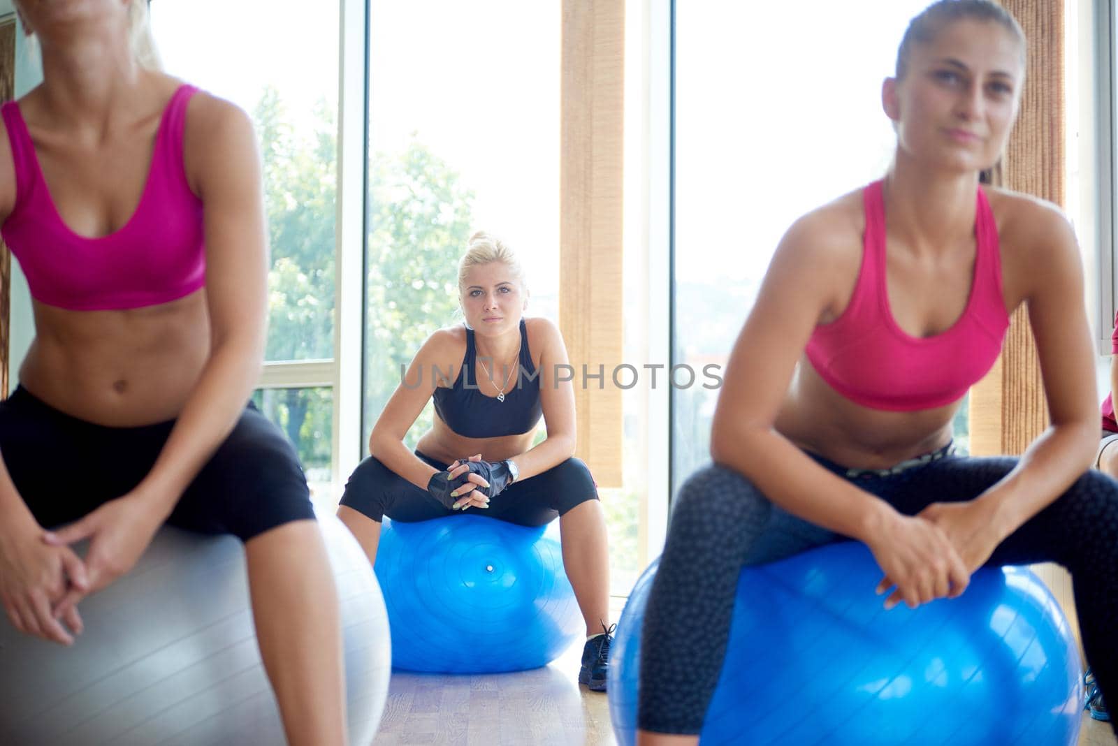group of people exercise with balls on yoga class in fitness gym