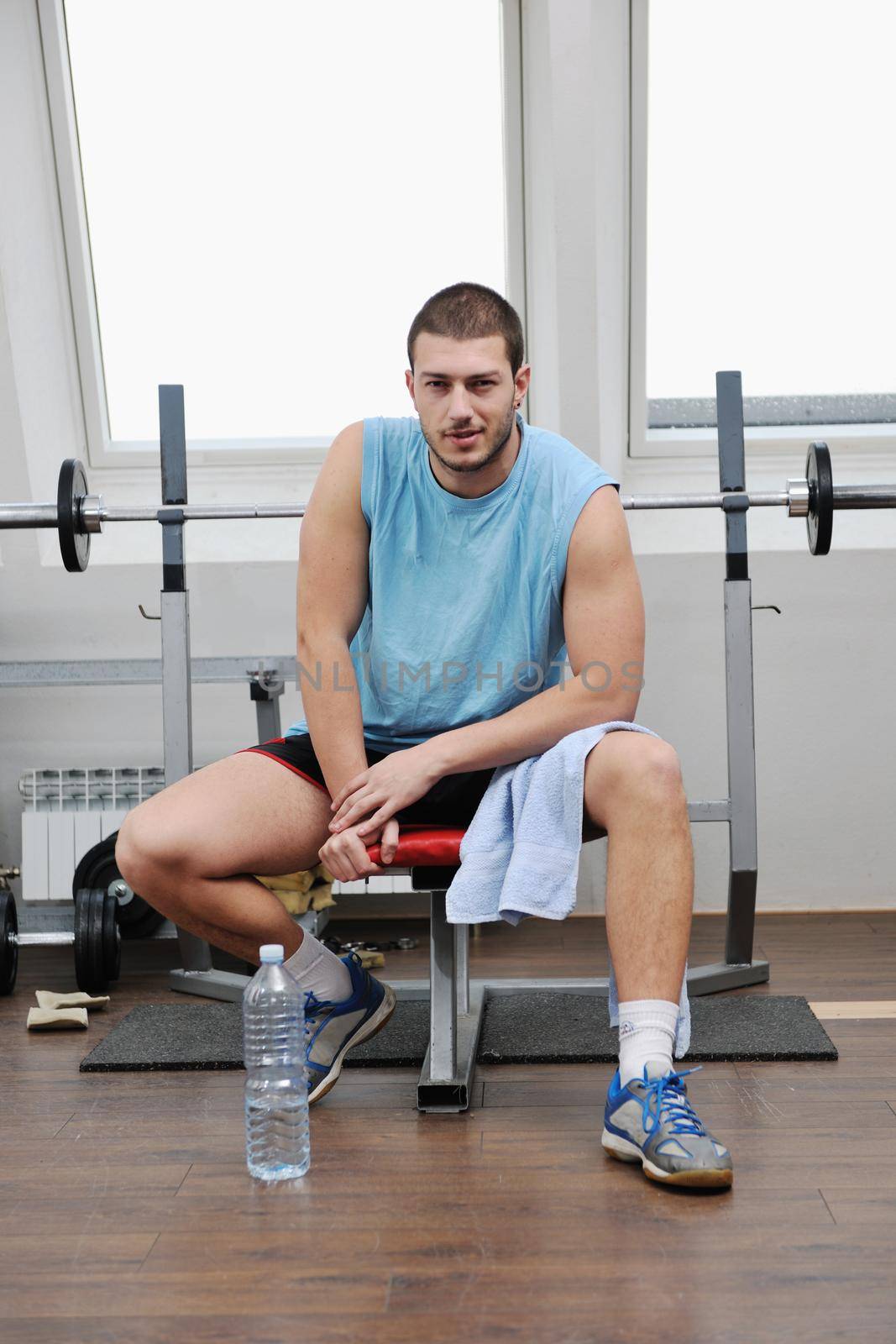 young man in fintess sport club exercise withweights and relaxing