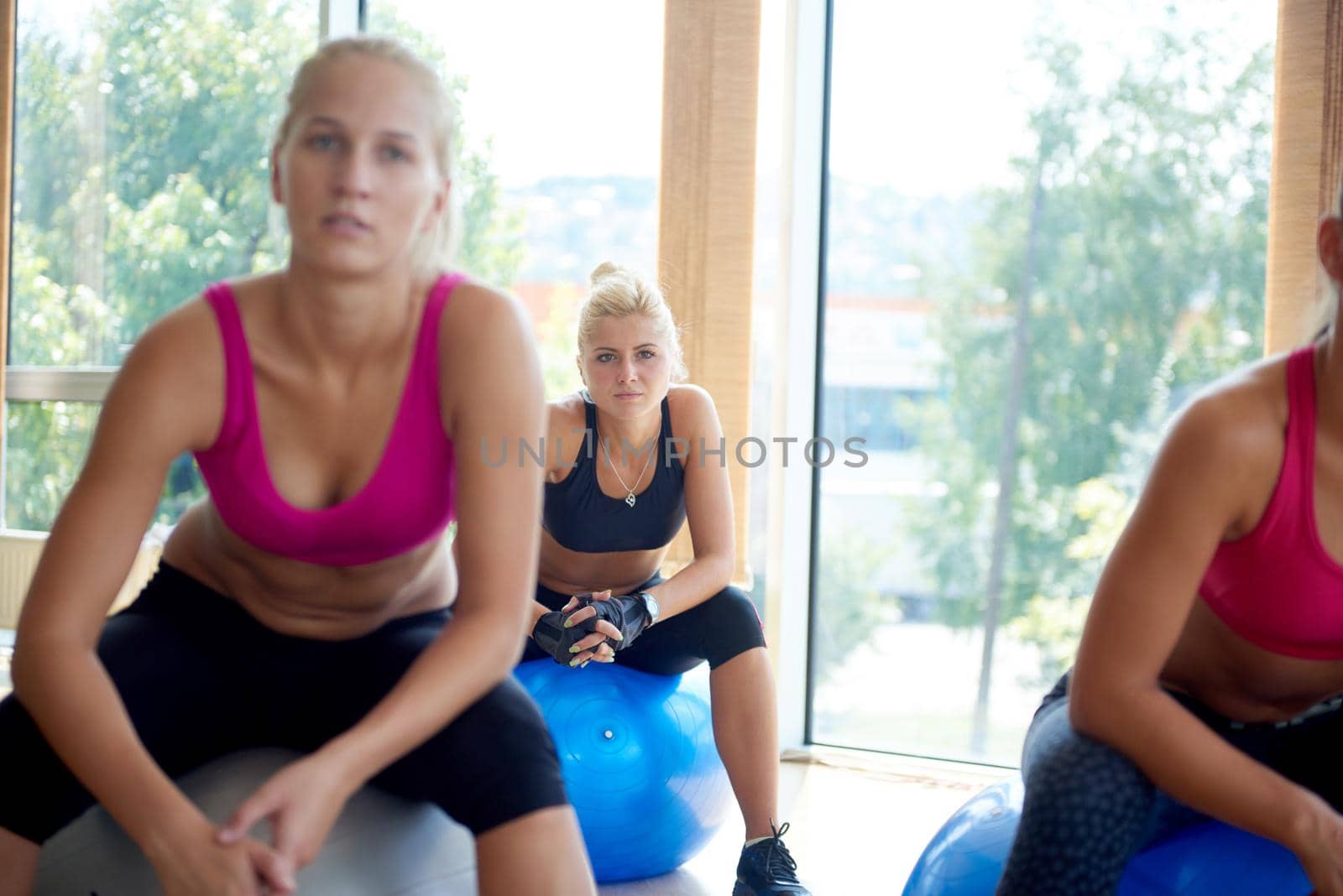 group of people exercise with balls on yoga class in fitness gym