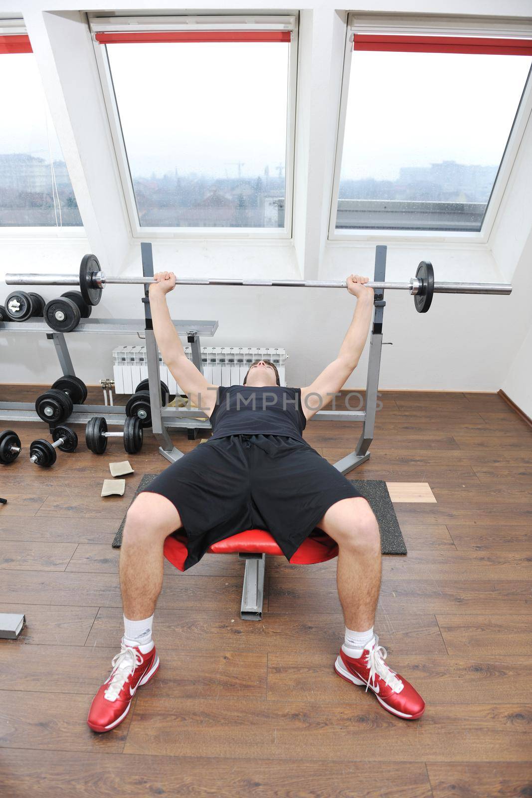 young man in fintess sport club exercise withweights and relaxing