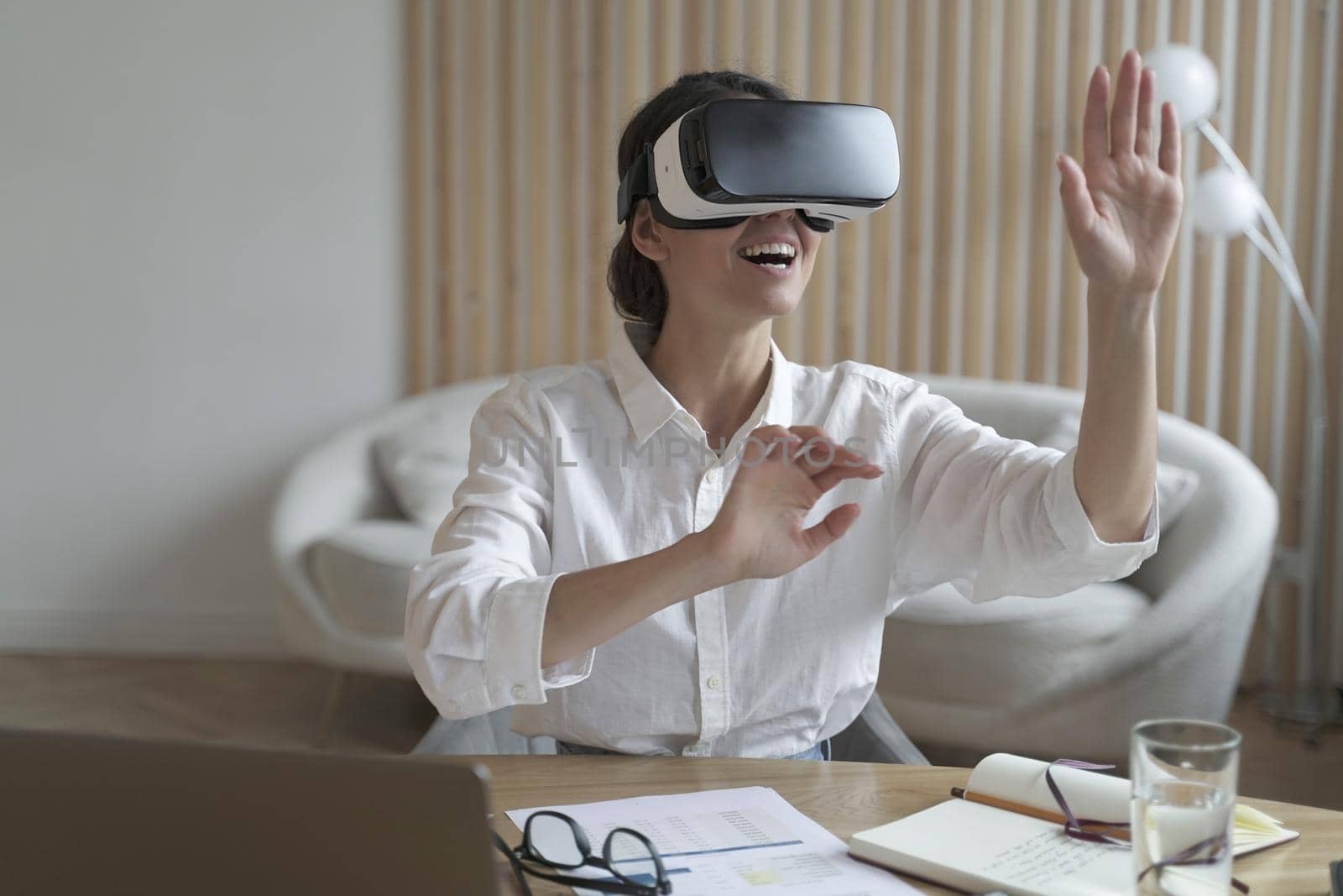 Cyberspace in business. Happy woman office worker wearing vr goggles, touching objects with hands in digital world, amazed businesswoman in 3d glasses interacting with virtual reality at work