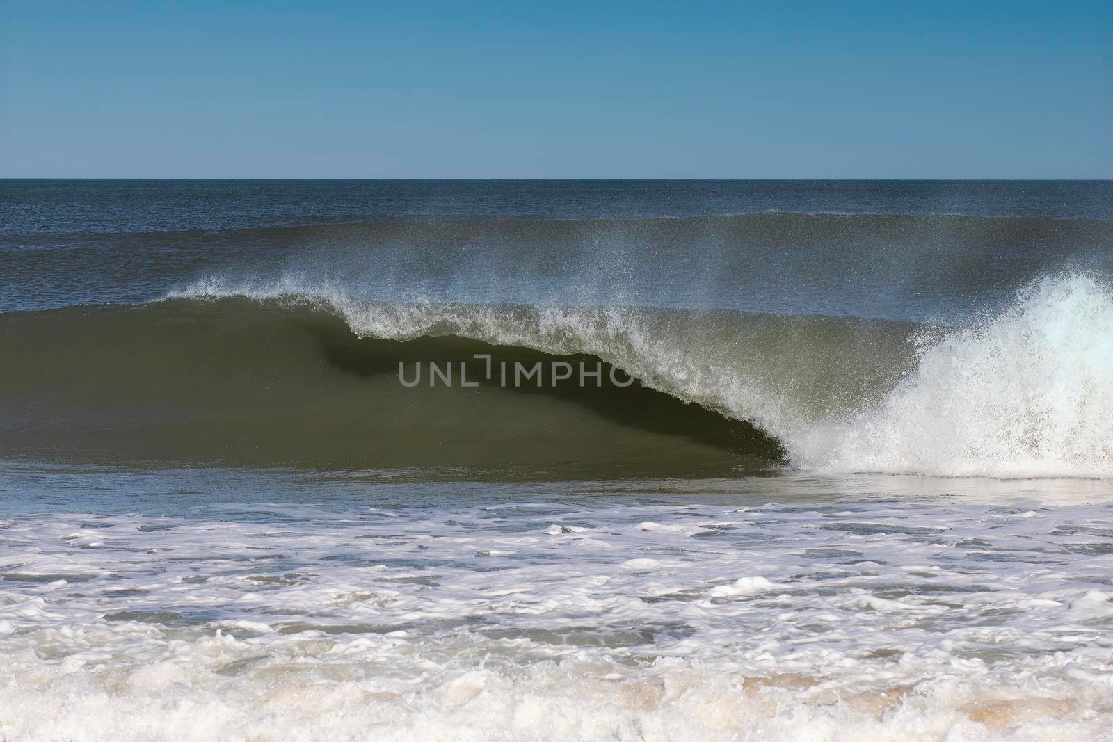 Breaking wave at Nags Head, North Carolina beach curls over.