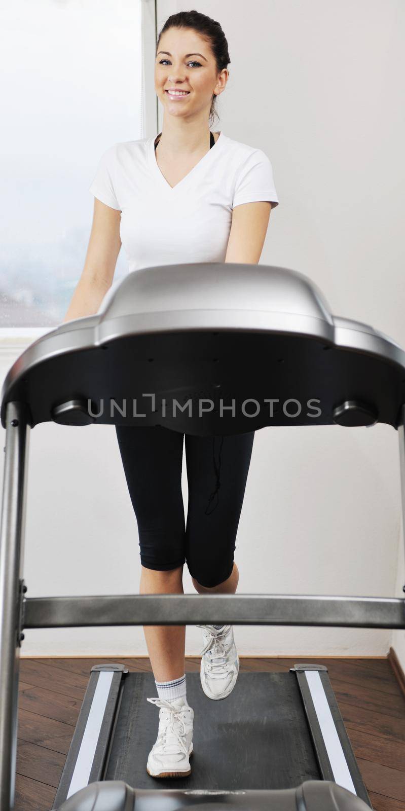 womanworkout  in fitness club on running track machine  by dotshock