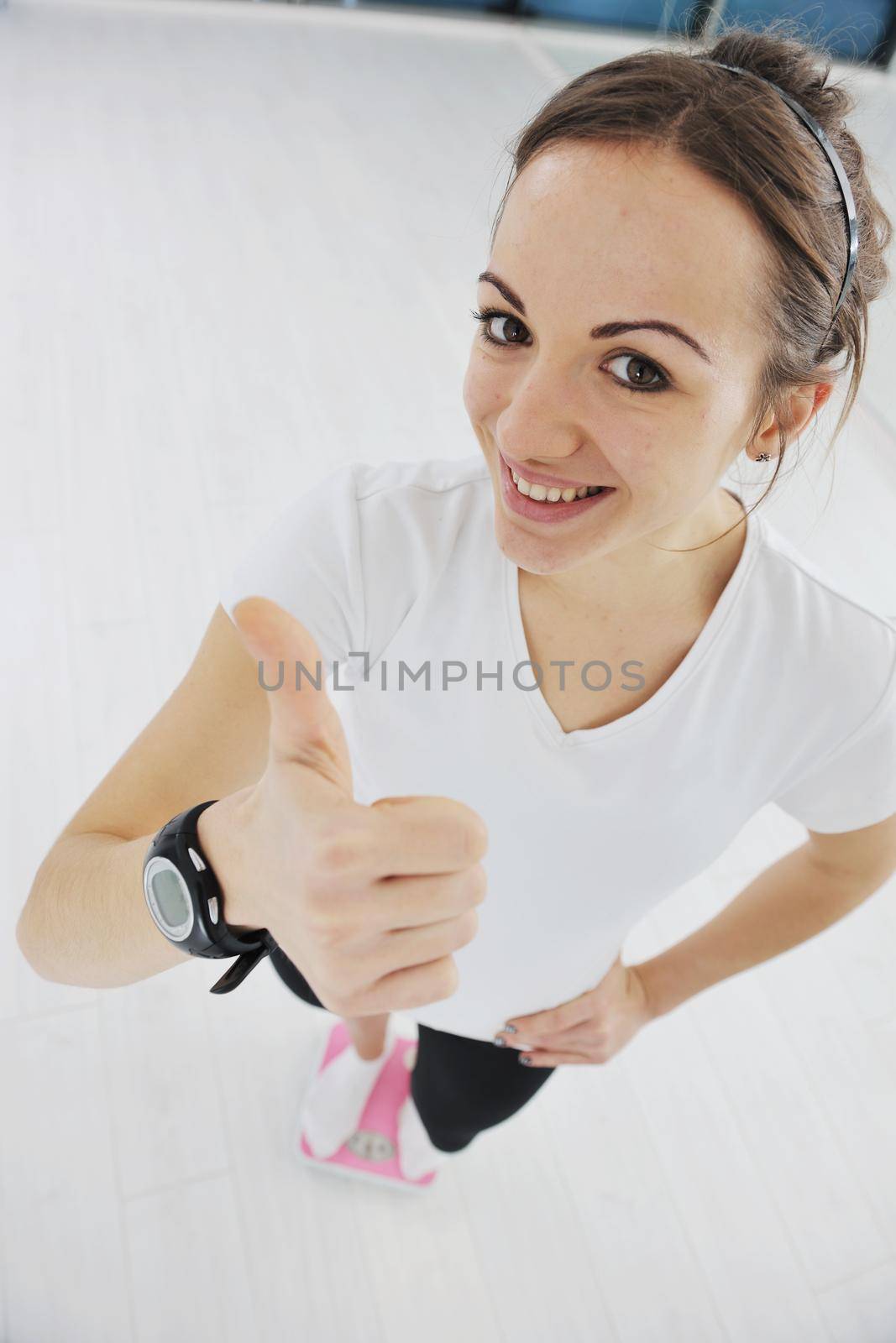 happy diet concept with young woman on pink scale at sport fitnes gym club