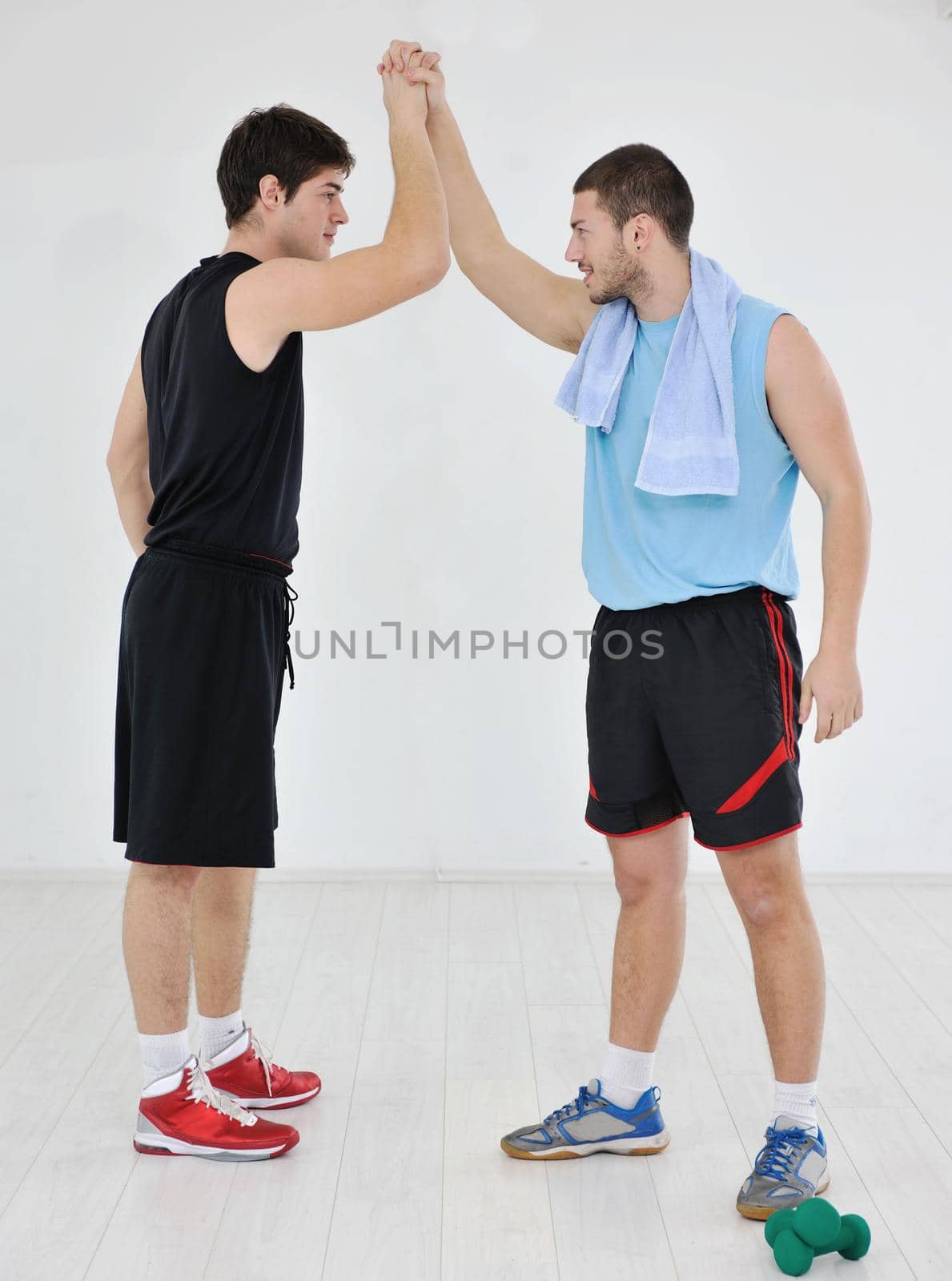 two young adults exercise fitness jumping and relaxing at sport gym club