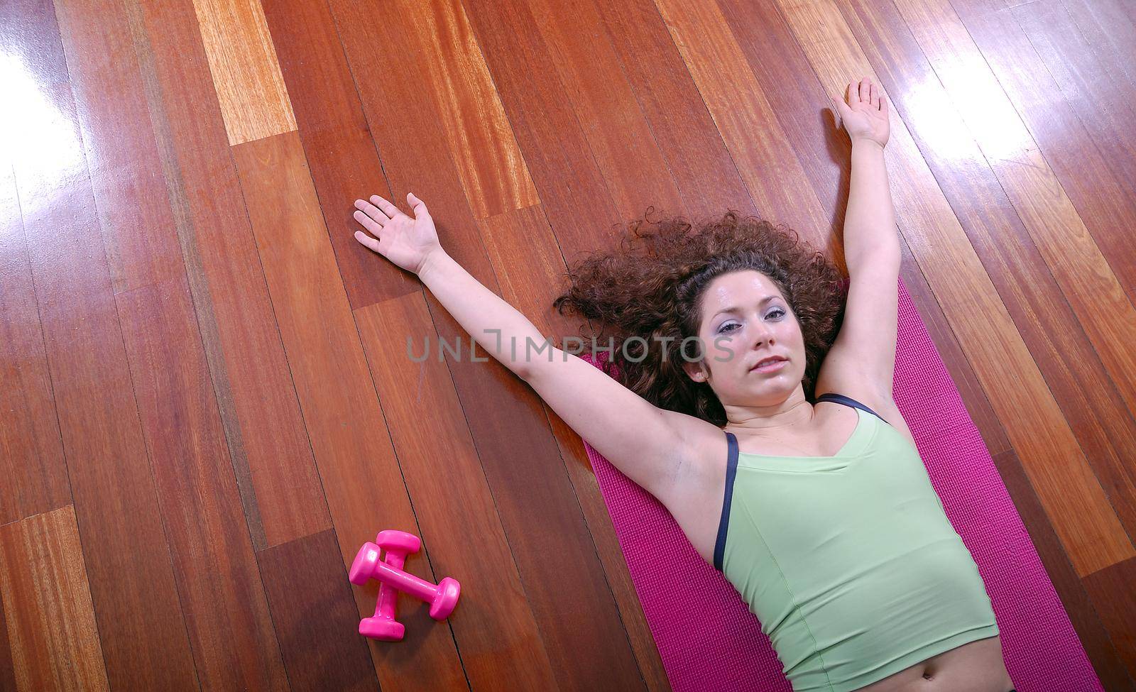 prety girl laying on back in fitness studio by dotshock