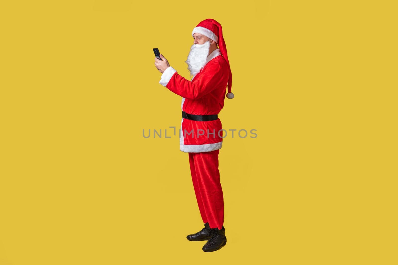 Santa claus yellow food style, braces tradition christmas aged, seniors. Red cheerful, smile with phone in hand by 89167702191