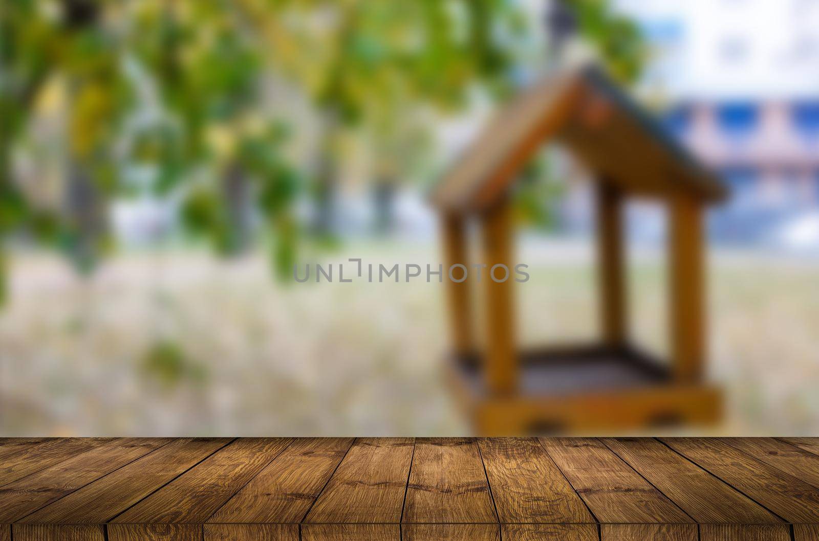 Empty wooden table with garden bokeh for a catering or food background with a country outdoor theme. by Andelov13