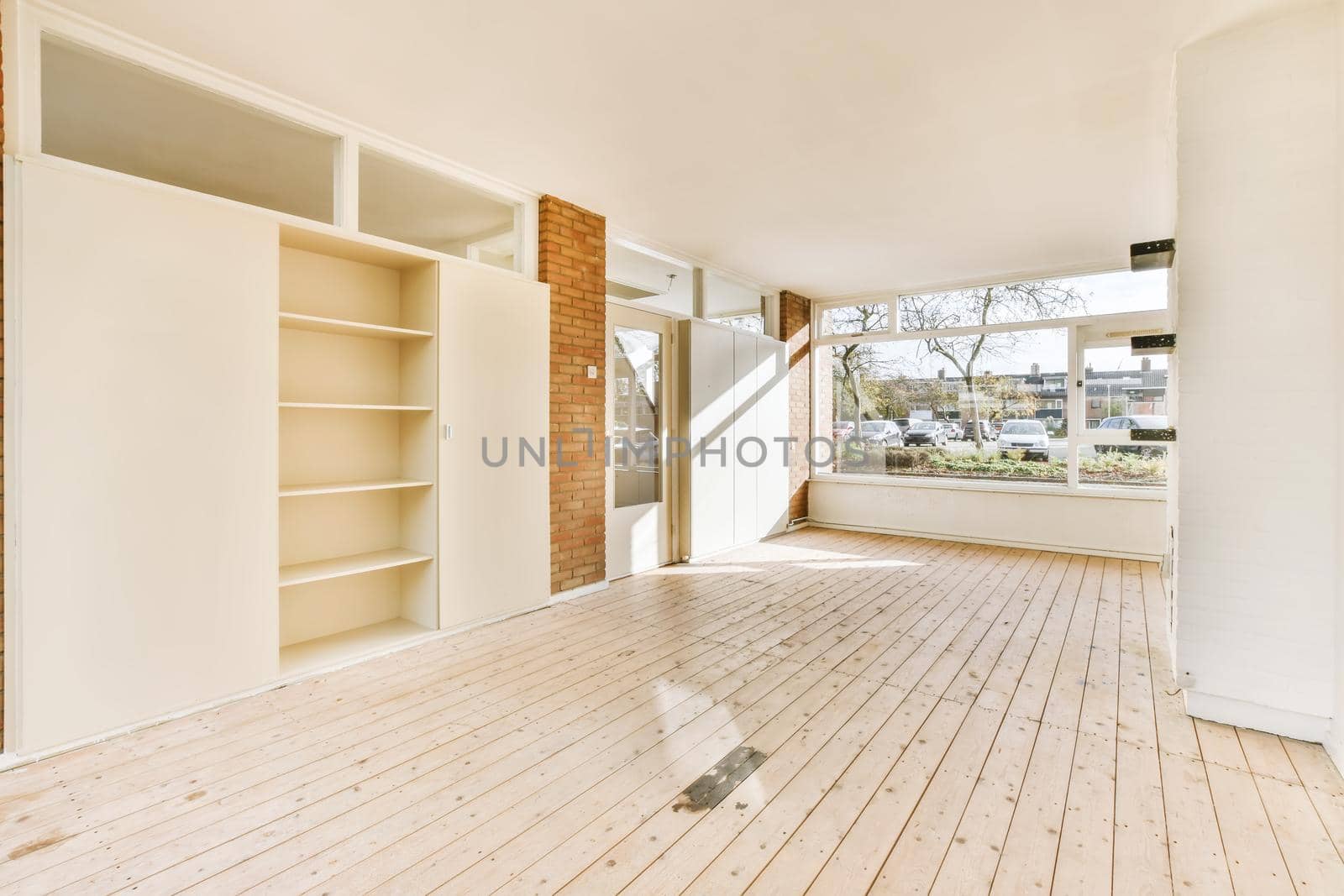 Large cozy empty room with window and wooden floor