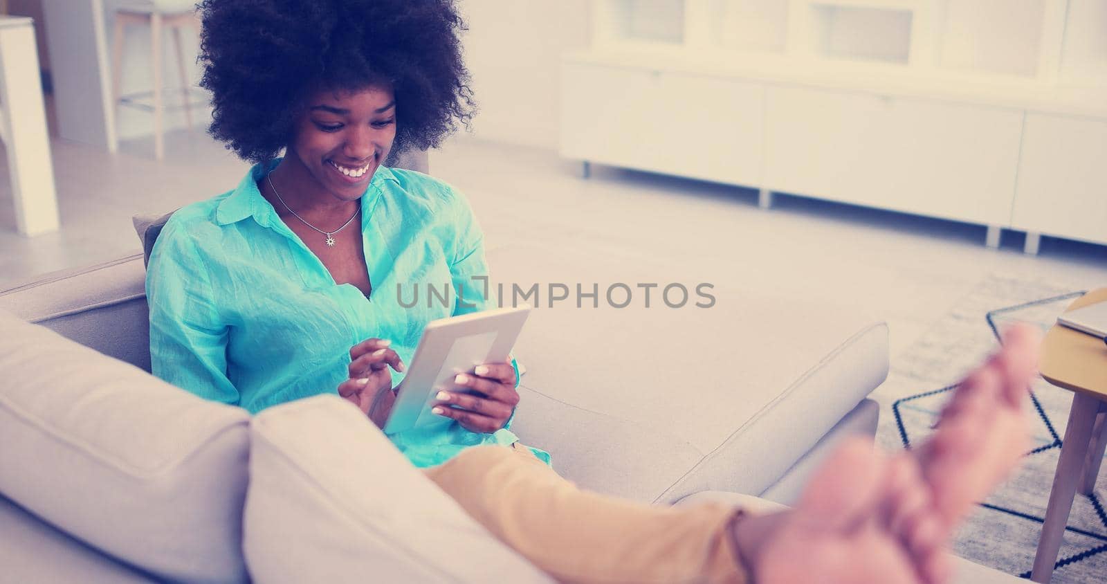 african american woman at home using digital tablet by dotshock