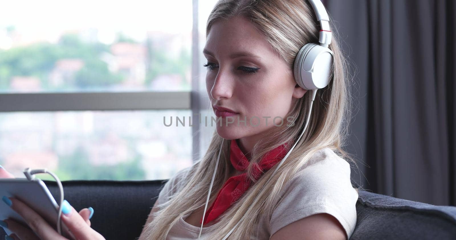 Lovely Blond Woman Listening To Music while resting on couch by dotshock