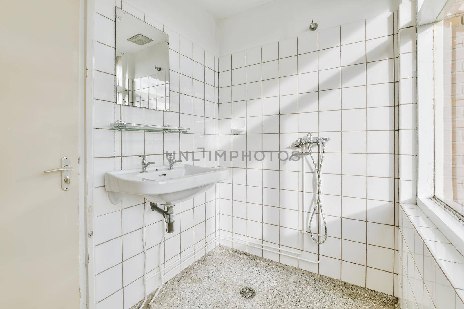Bathroom with white tiles and a window to the street