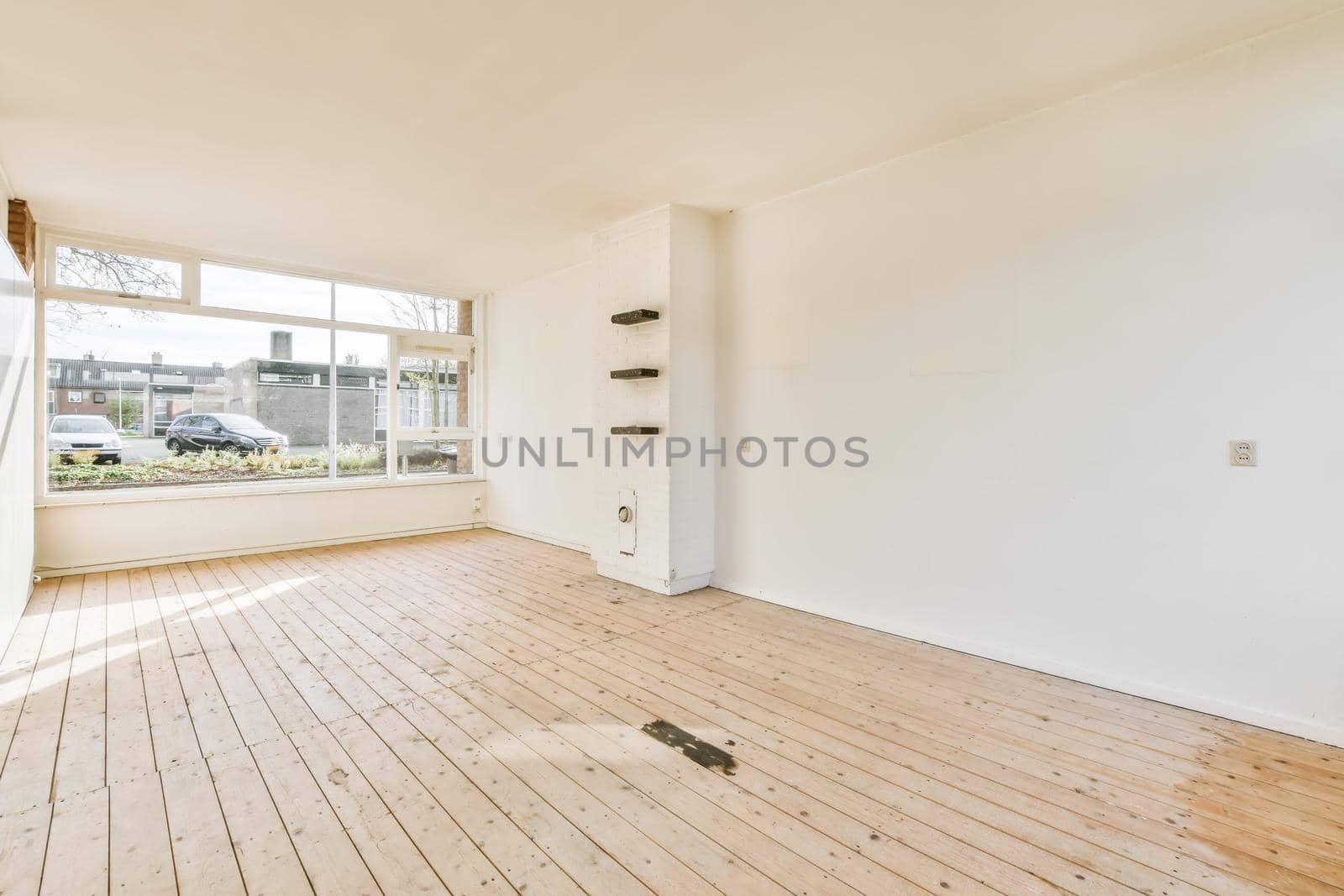 Large cozy empty room with window and wooden floor
