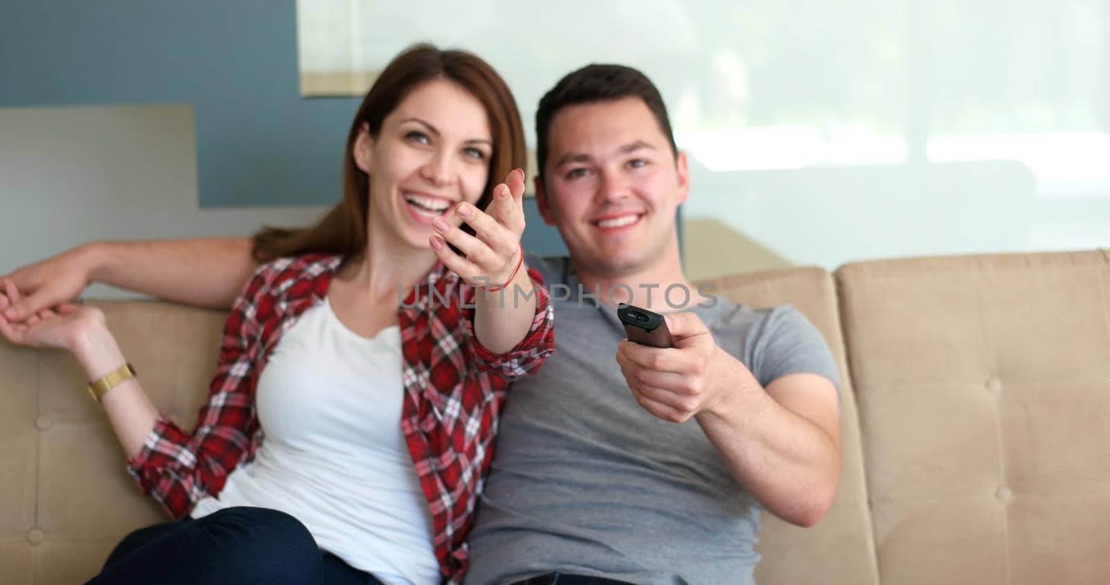 Young couple watching tv in the living roonm
