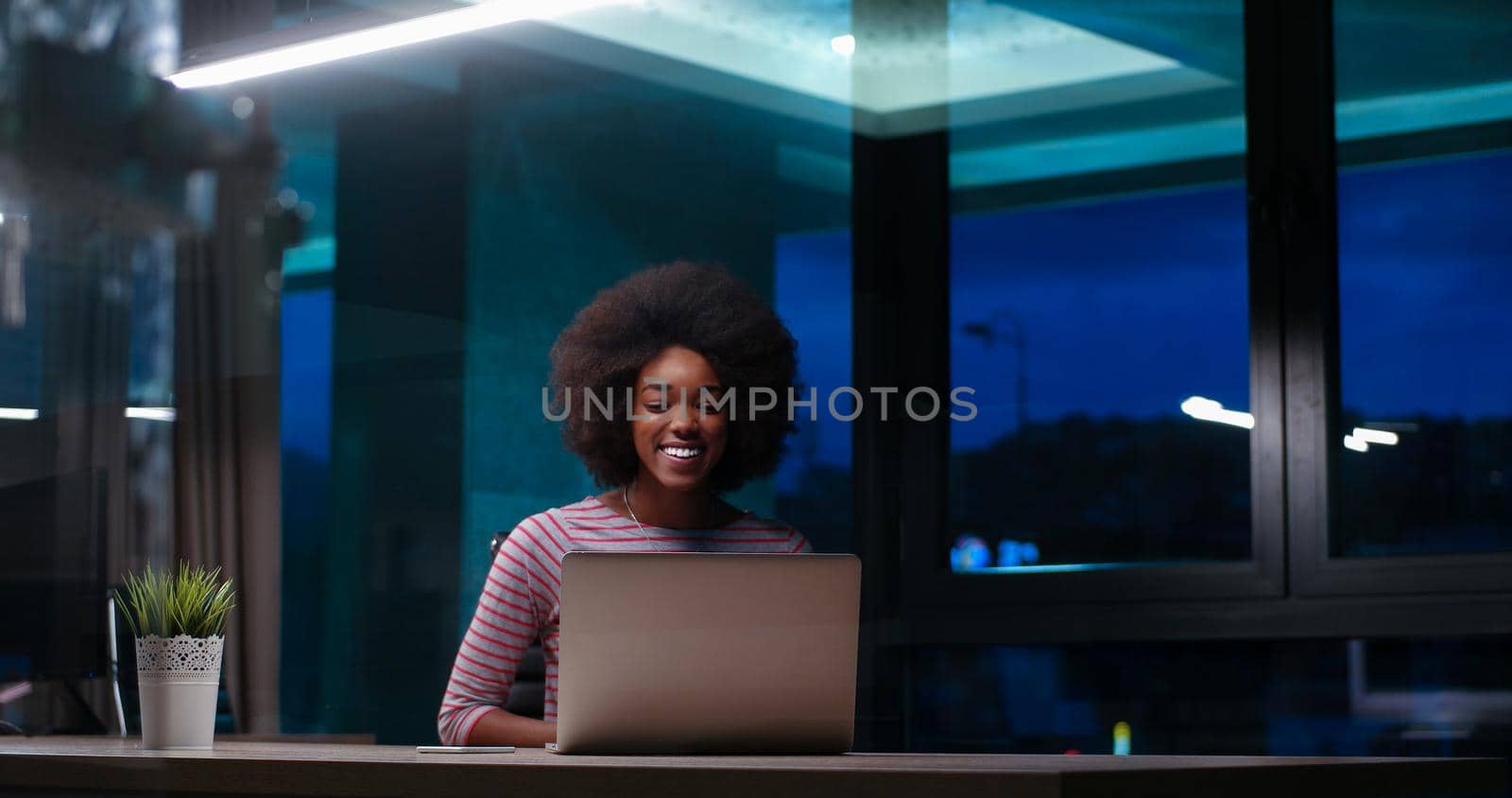 Young african american female Entrepreneur Freelancer Working Using A Laptop In night Coworking space