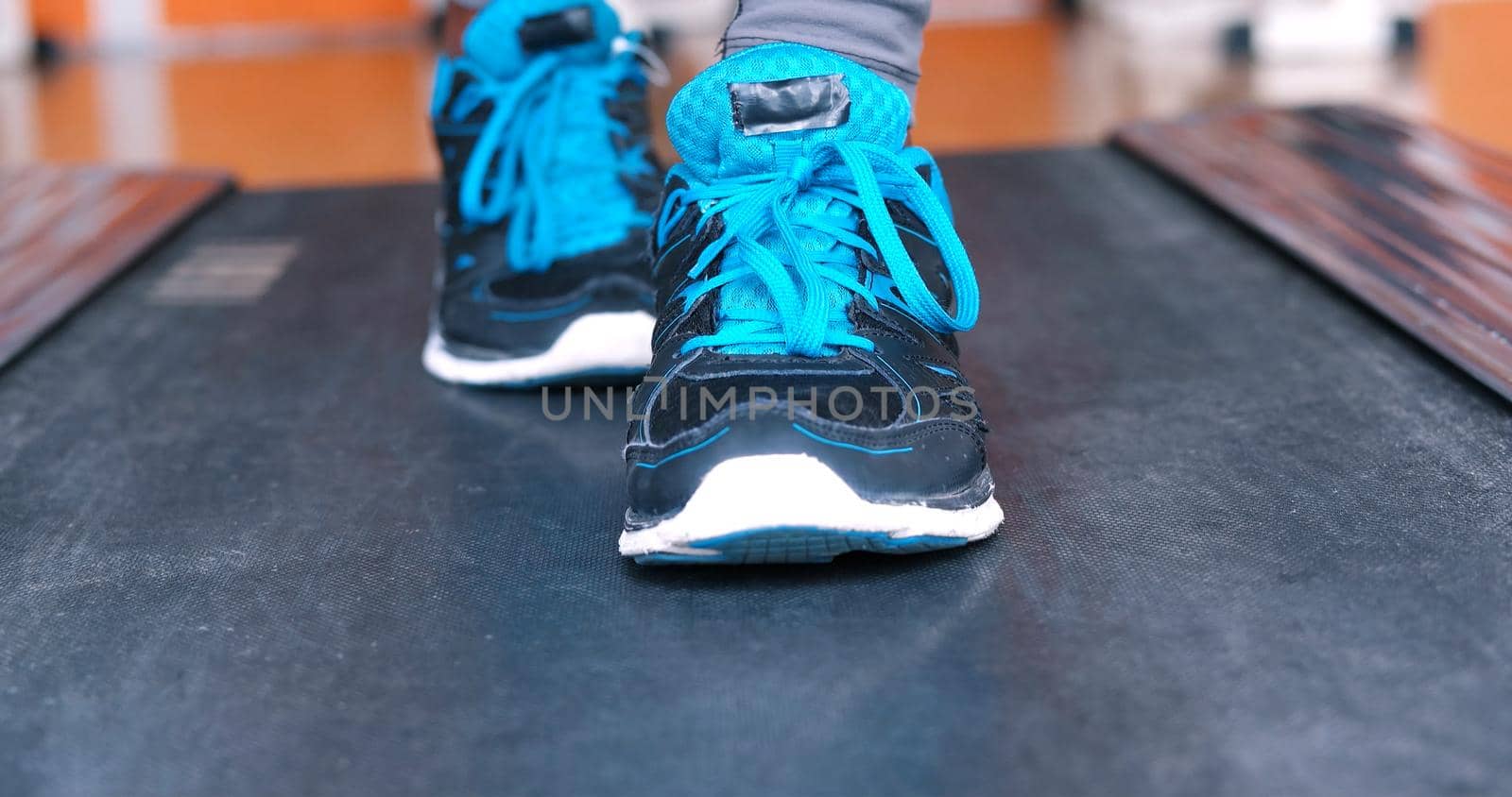Close up of running black female feet in sneakers in gym