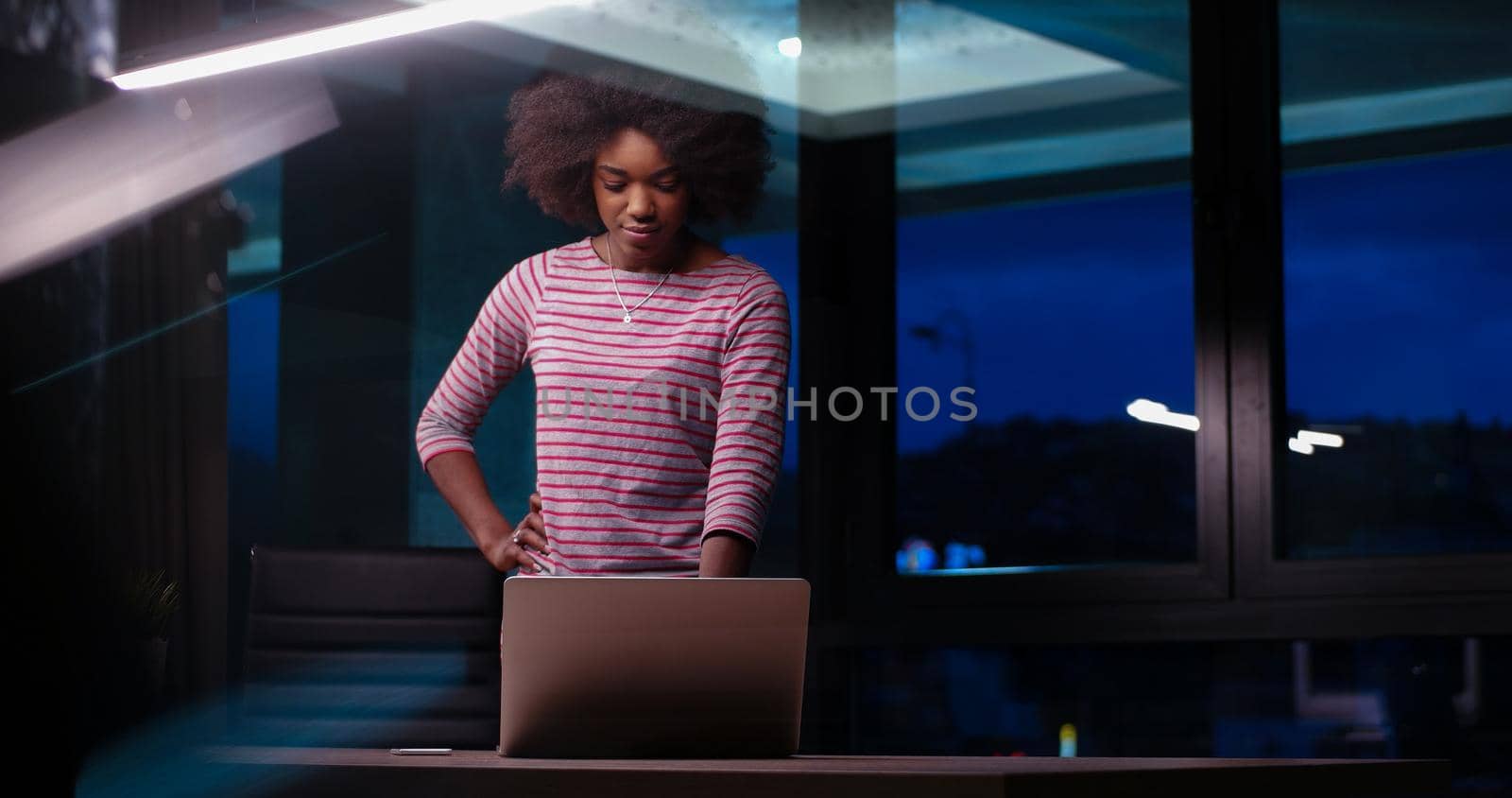 Young african american female Entrepreneur Freelancer Working Using A Laptop In night Coworking space