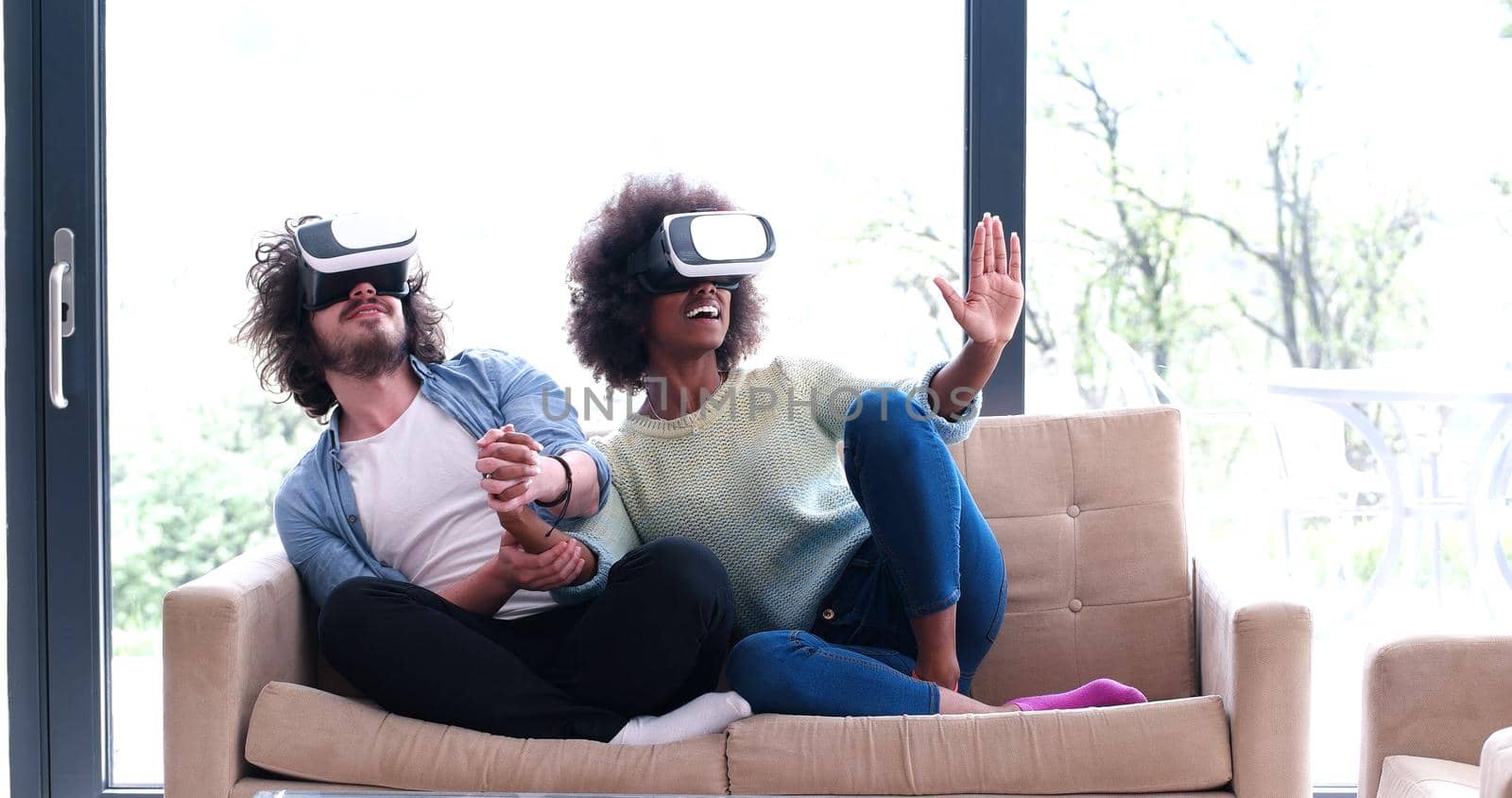 Multiethnic Couple using virtual reality headset in living room at home  people playing game with new trends technology