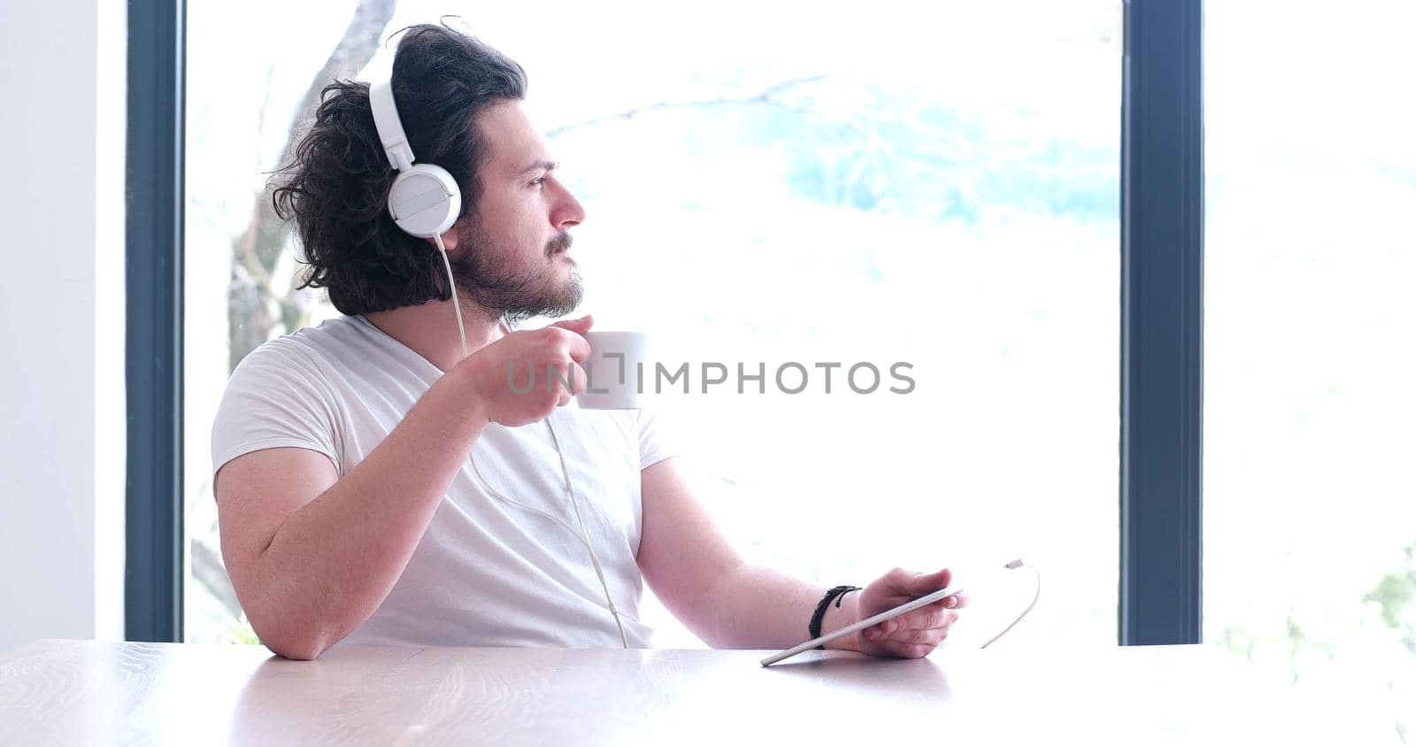 young man listenig music on tablet at home by dotshock