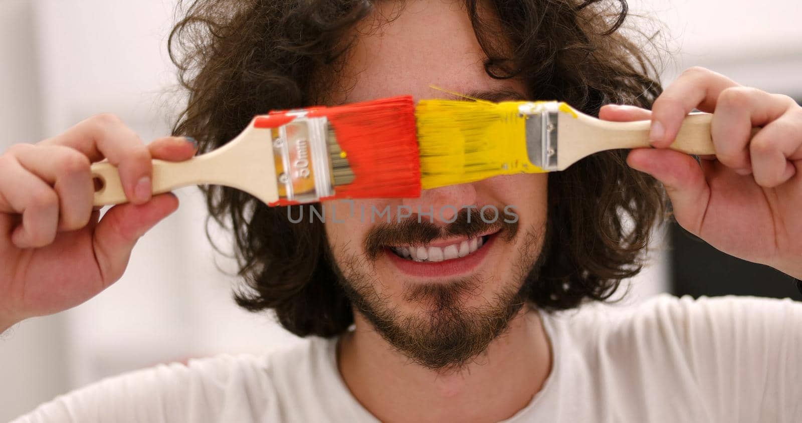 Portrait of a beautiful  young man with funny hair and brush over color background with copyspace expressing different emotions