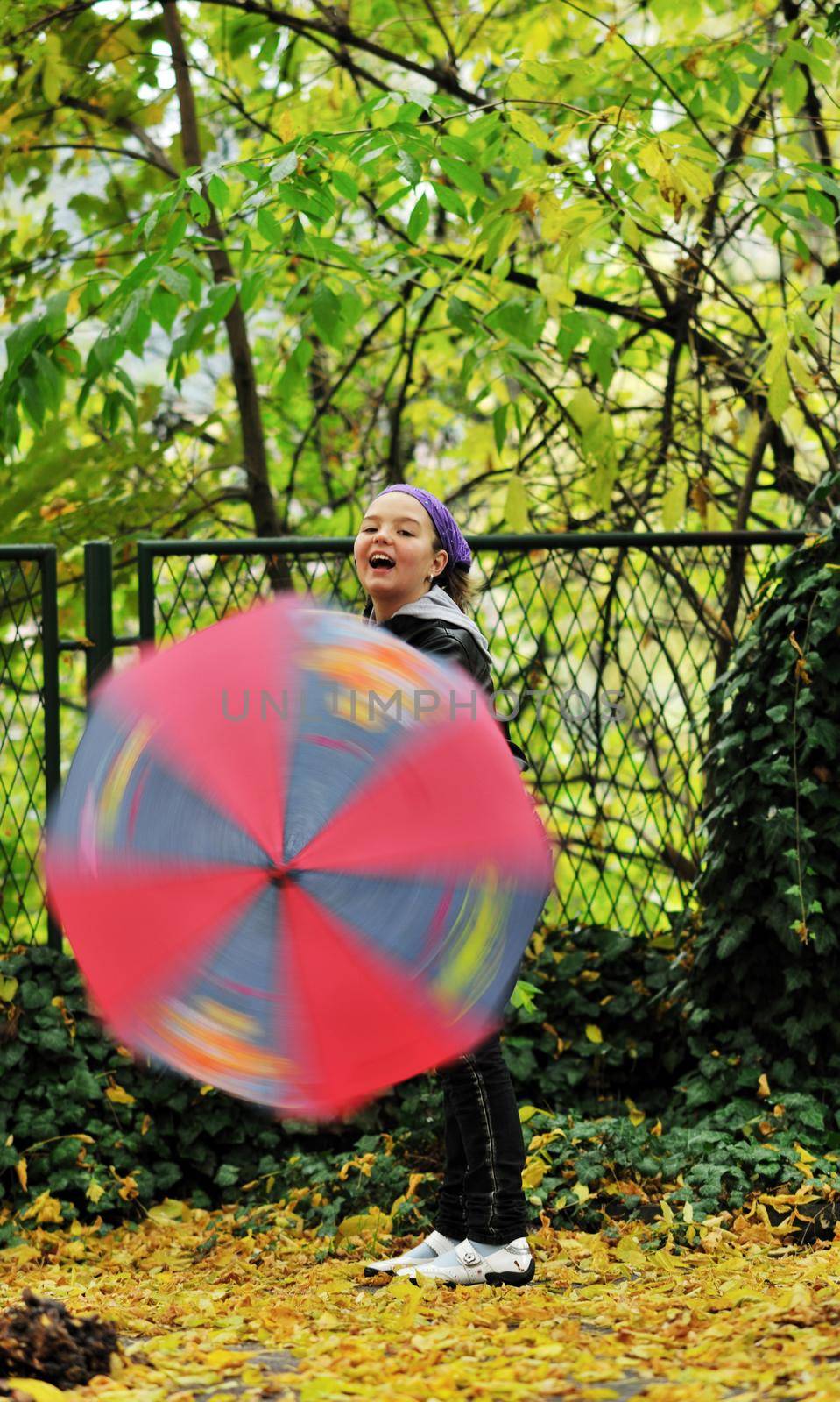 happy girl with umbrella outdoor in park on autumn season rain day