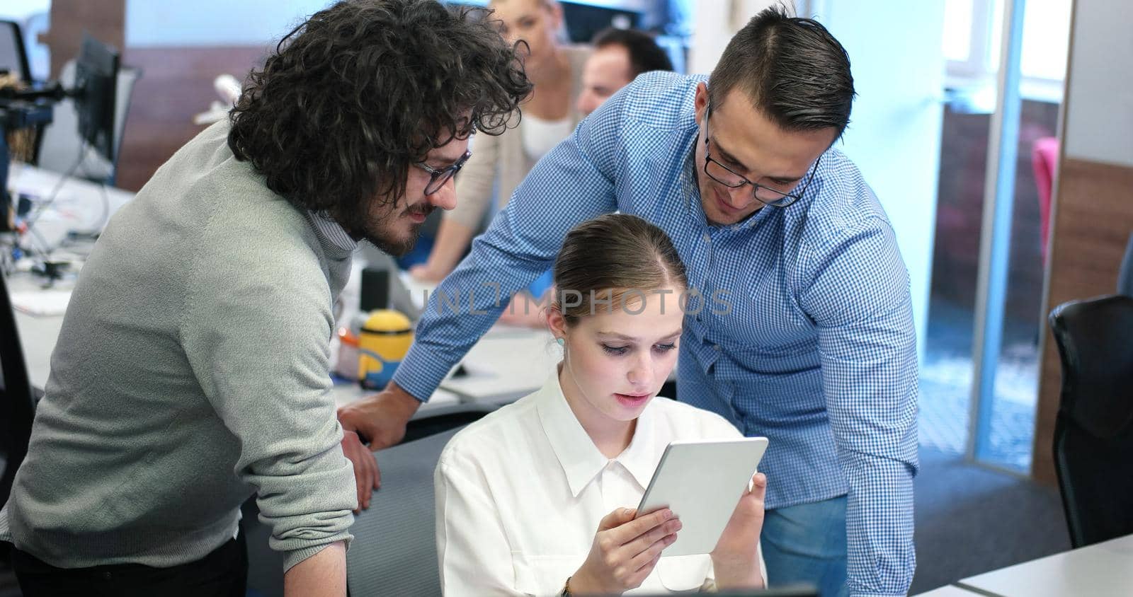 Group of a young business people discussing business plan at modern startup office building