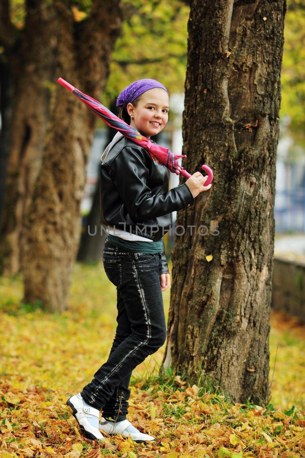 happy girl with umbrella outdoor in park on autumn season rain day