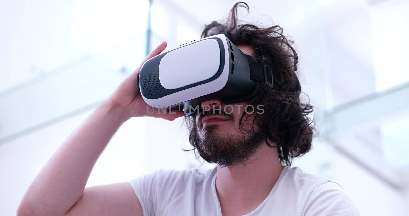 happy man getting experience using VR-headset glasses of virtual reality at home